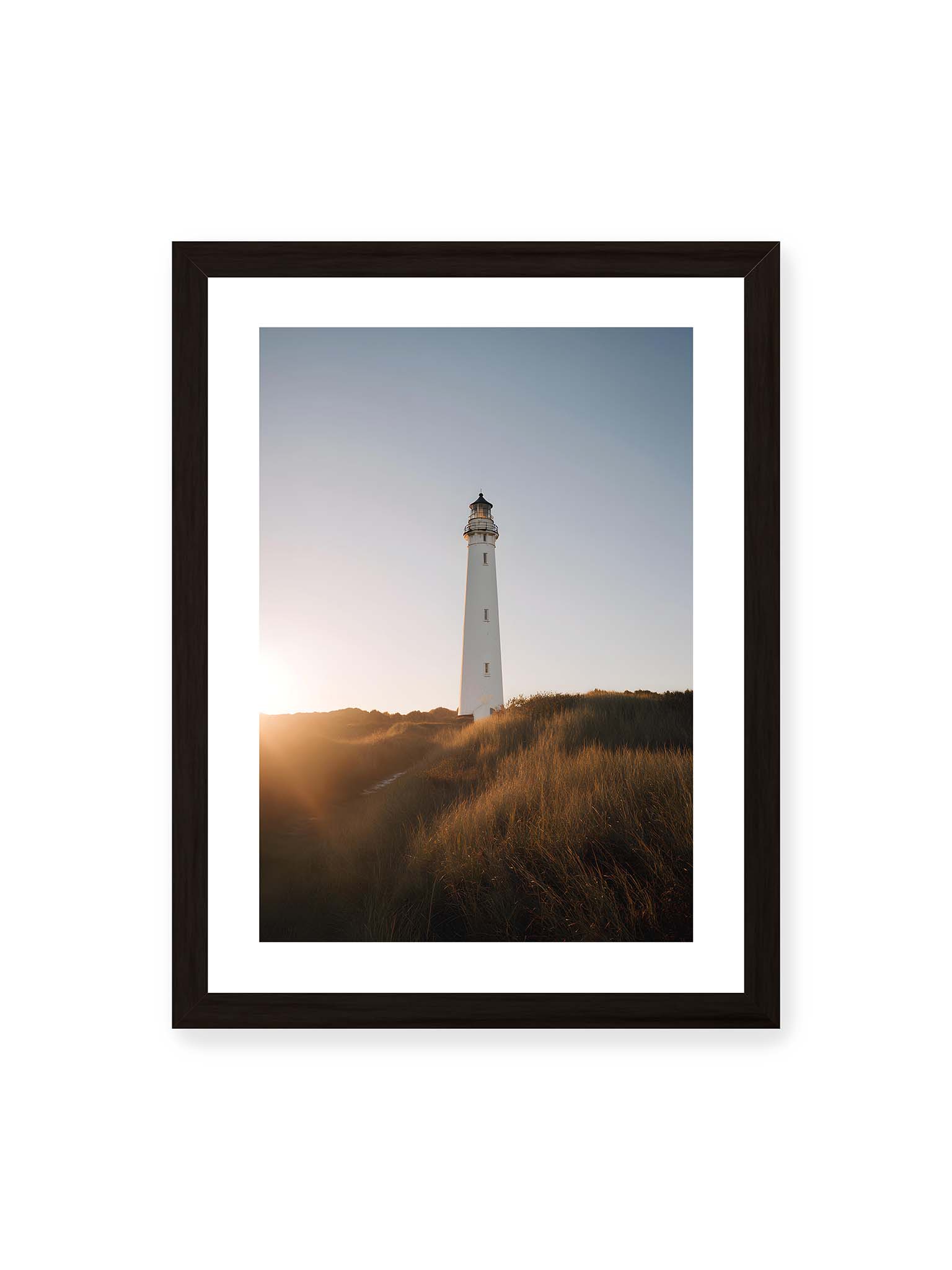30x40 cm, weißer Galerie-Rand, schwarzer Rahmen – Weißer Leuchtturm über Dünen im warmen Abendlicht mit sanftem Himmel im Hintergrund.
