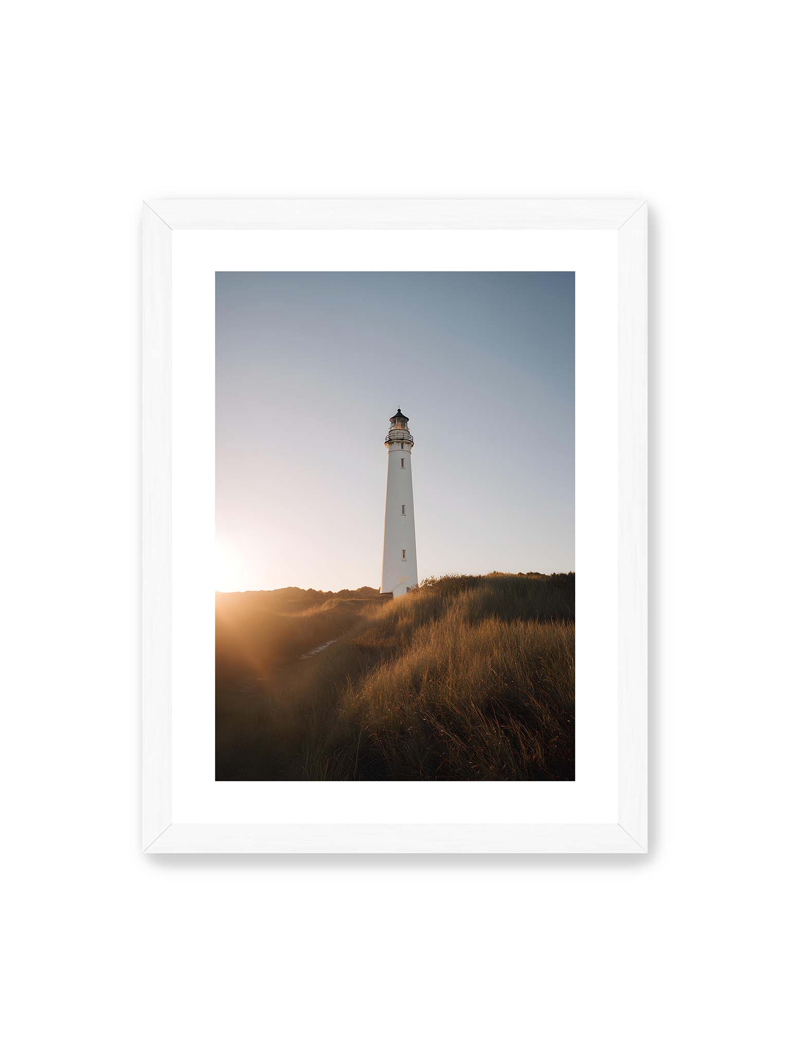 30x40 cm, weißer Galerie-Rand, weißer Rahmen – Weißer Leuchtturm über Dünen im warmen Abendlicht mit sanftem Himmel im Hintergrund.