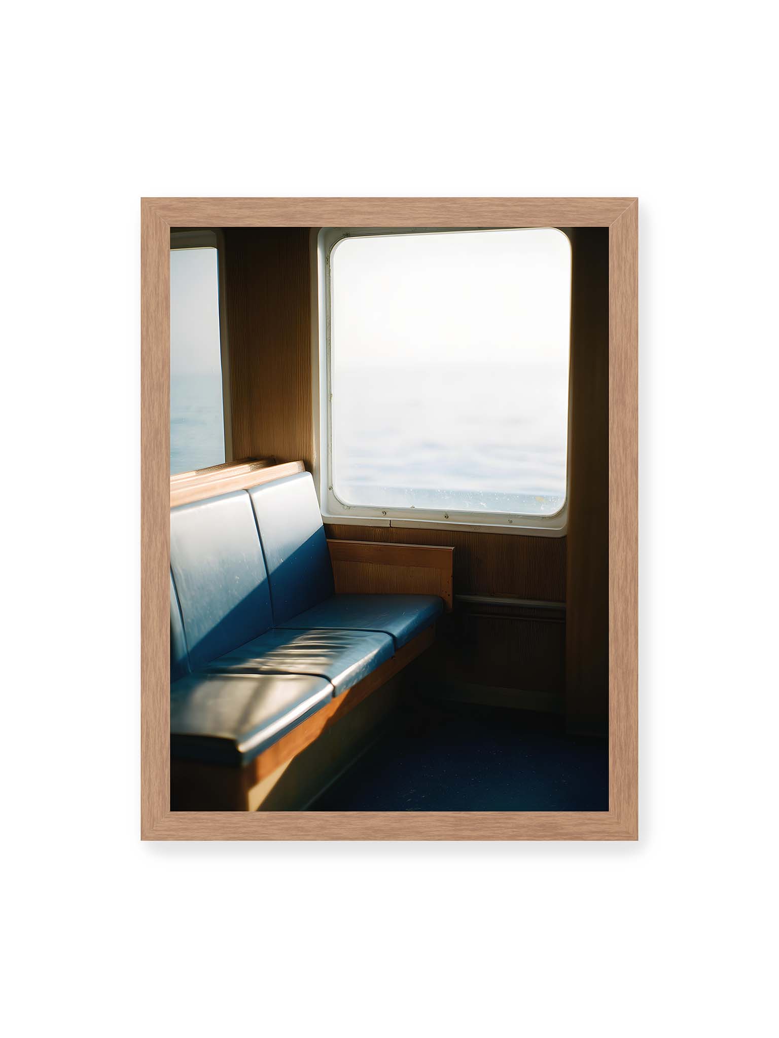 30x40 cm, Eichenrahmen – Leerer Sitzplatz neben einem Fenster mit warmem Licht und unscharfer Aussicht auf das offene Meer.