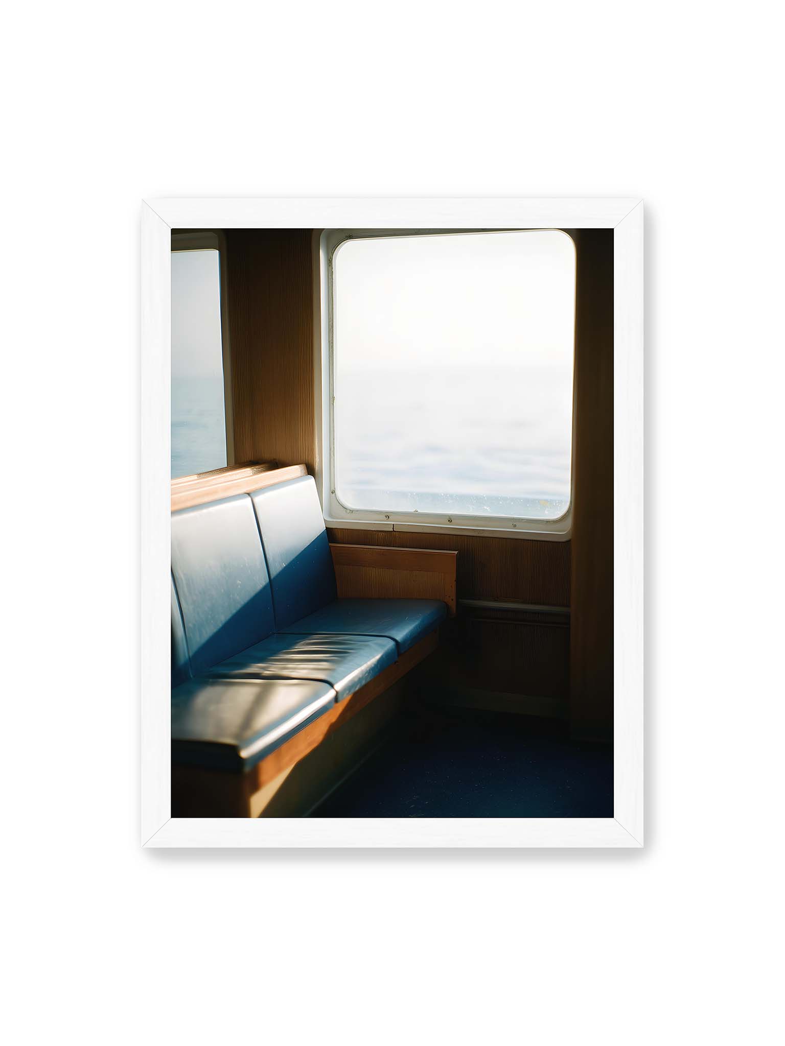 30x40 cm, weißer Rahmen – Leerer Sitzplatz neben einem Fenster mit warmem Licht und unscharfer Aussicht auf das offene Meer.