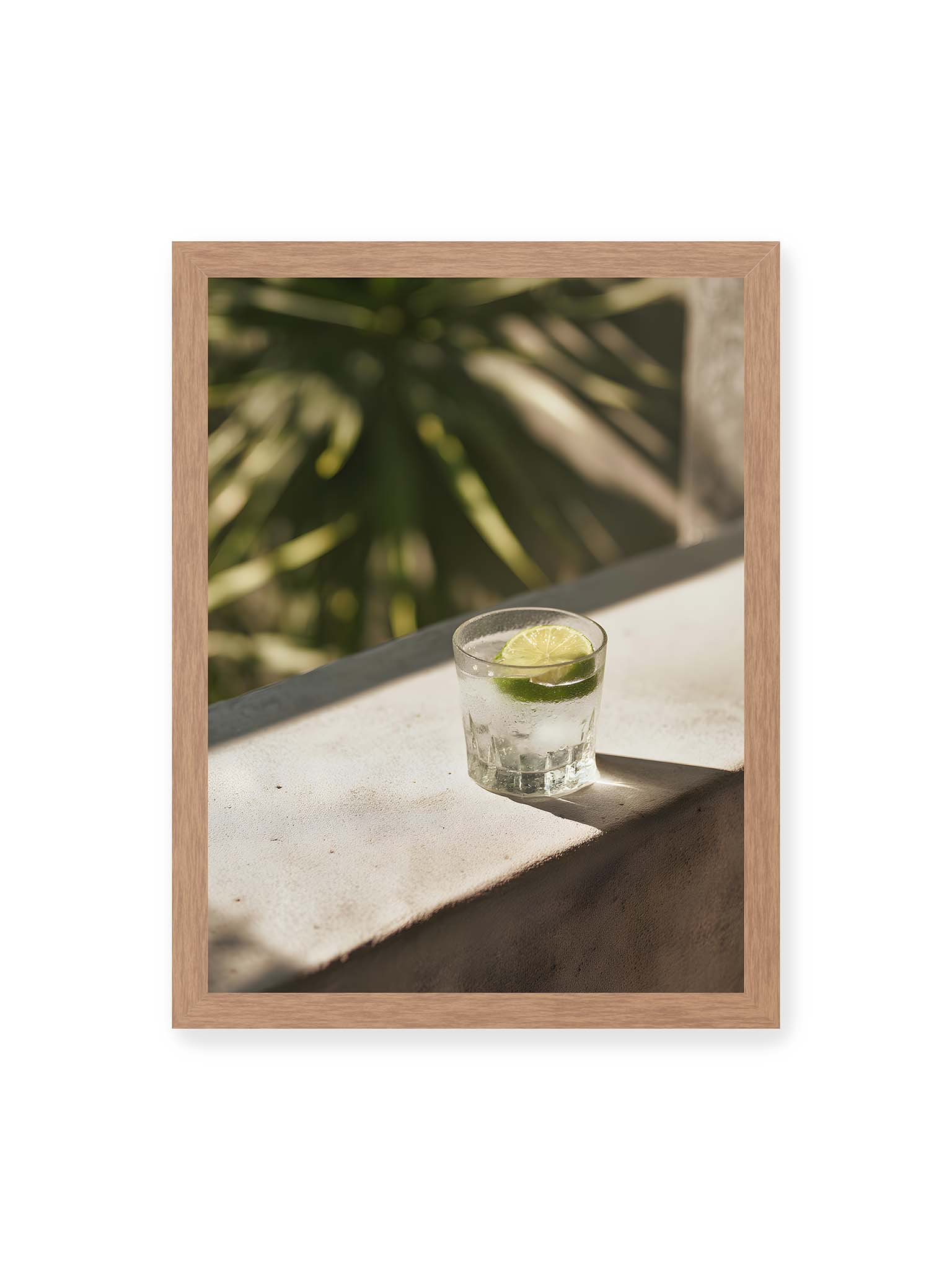 30x40 cm, Eichenrahmen – Glas mit Eis und Limettenscheibe auf heller Oberfläche im warmen Licht mit tropischen Schatten.
