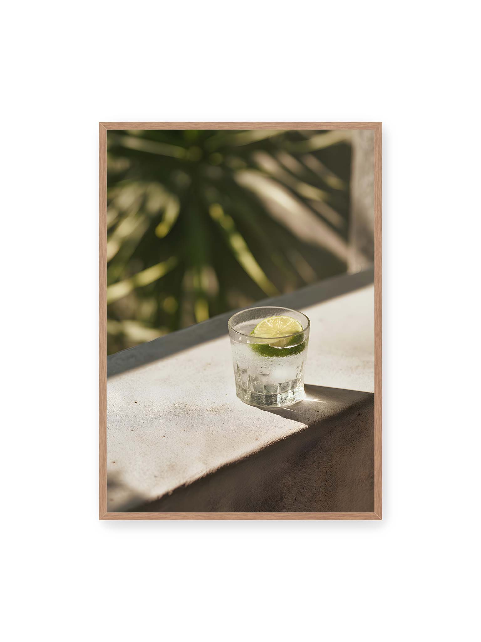 70x100 cm, Eichenrahmen – Glas mit Eis und Limettenscheibe auf heller Oberfläche im warmen Licht mit tropischen Schatten.