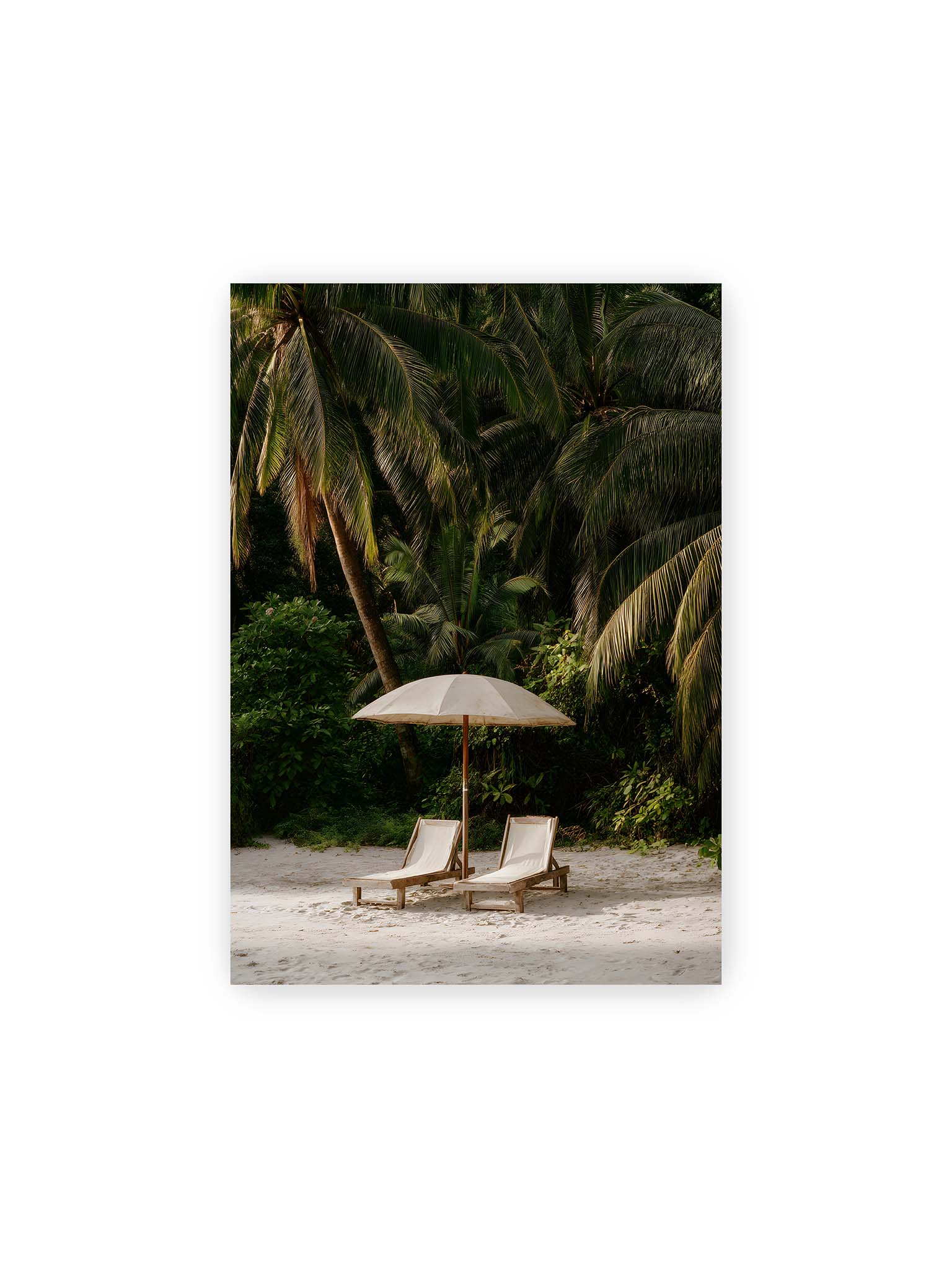 21x30 cm – Zwei Liegen unter einem Sonnenschirm am tropischen Strand mit Palmen und weichem Licht im Hintergrund.