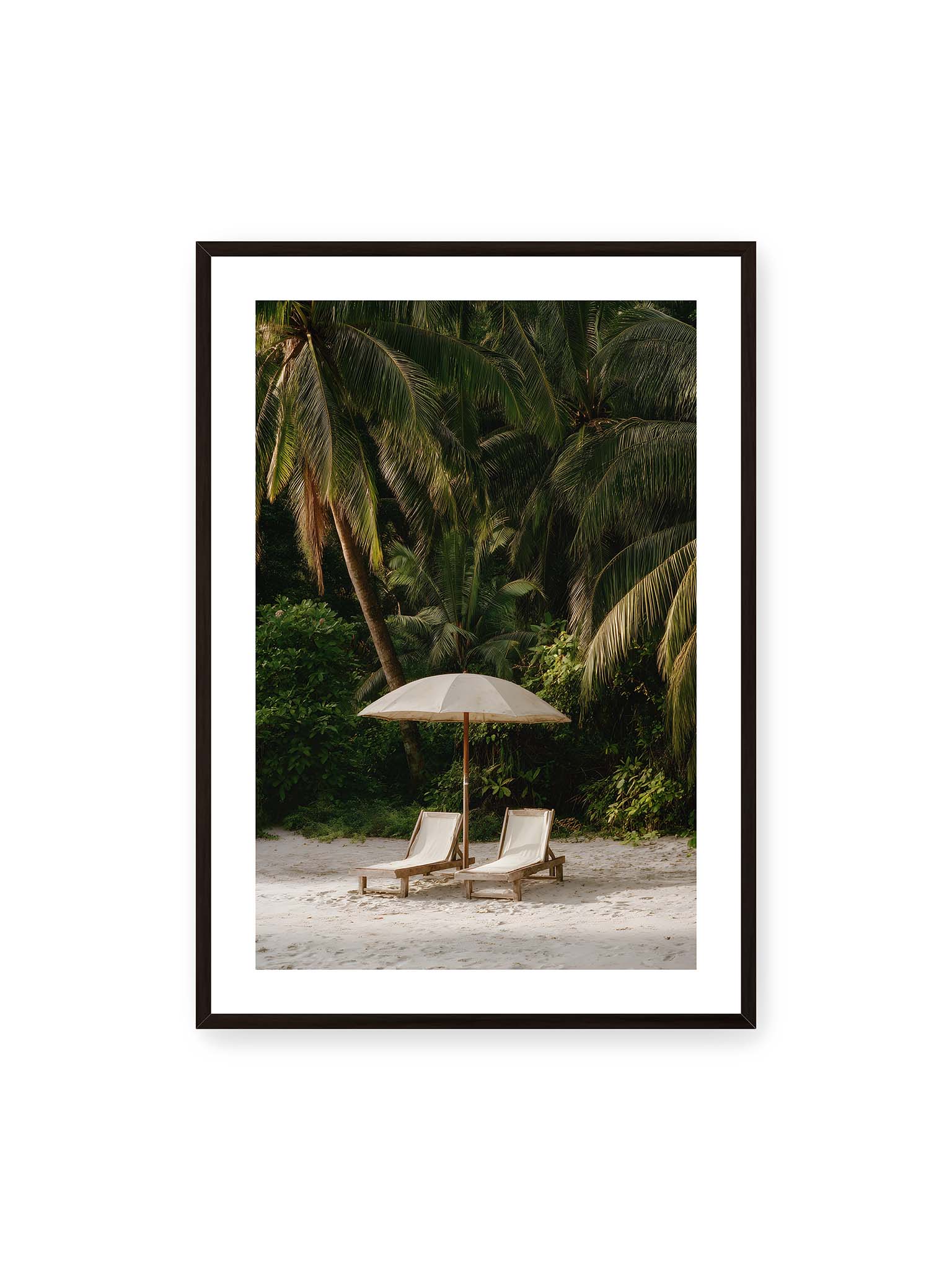 70x100 cm, weißer Galerie-Rand, schwarzer Rahmen – Zwei Liegen unter einem Sonnenschirm am tropischen Strand mit Palmen und weichem Licht im Hintergrund.