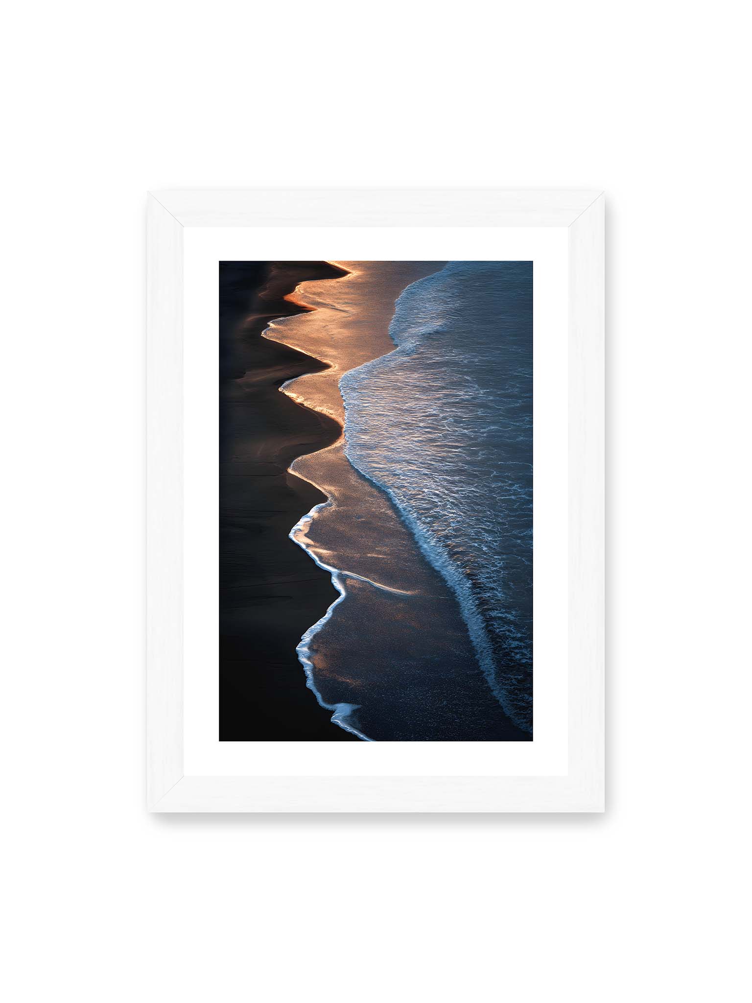 21x30 cm, weißer Galerie-Rand, weißer Rahmen – Goldene Wellenlinien treffen auf dunklen Strand mit starkem Kontrast zwischen Licht und Schatten entlang der Küste.