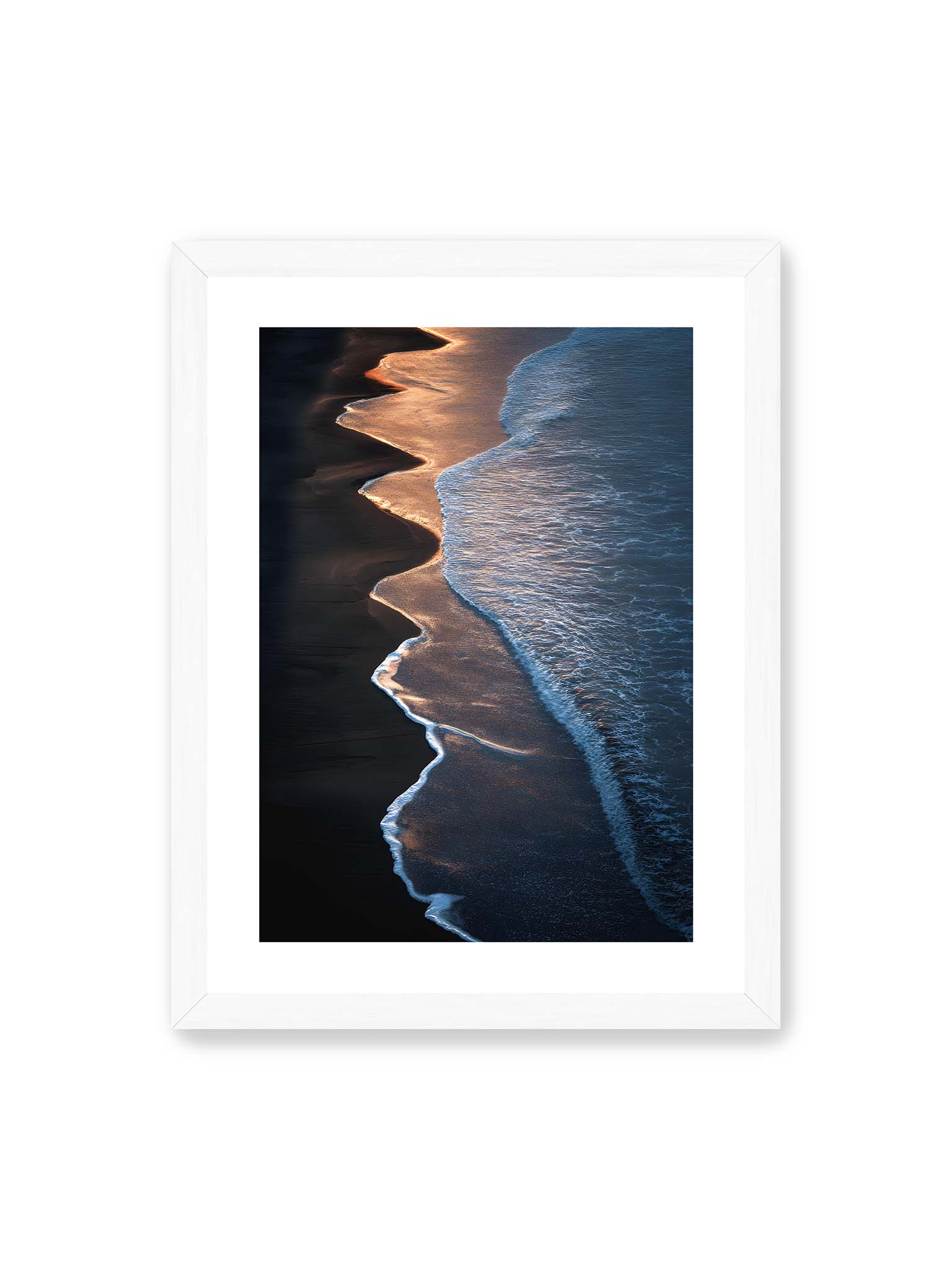 30x40 cm, weißer Galerie-Rand, weißer Rahmen – Goldene Wellenlinien treffen auf dunklen Strand mit starkem Kontrast zwischen Licht und Schatten entlang der Küste.