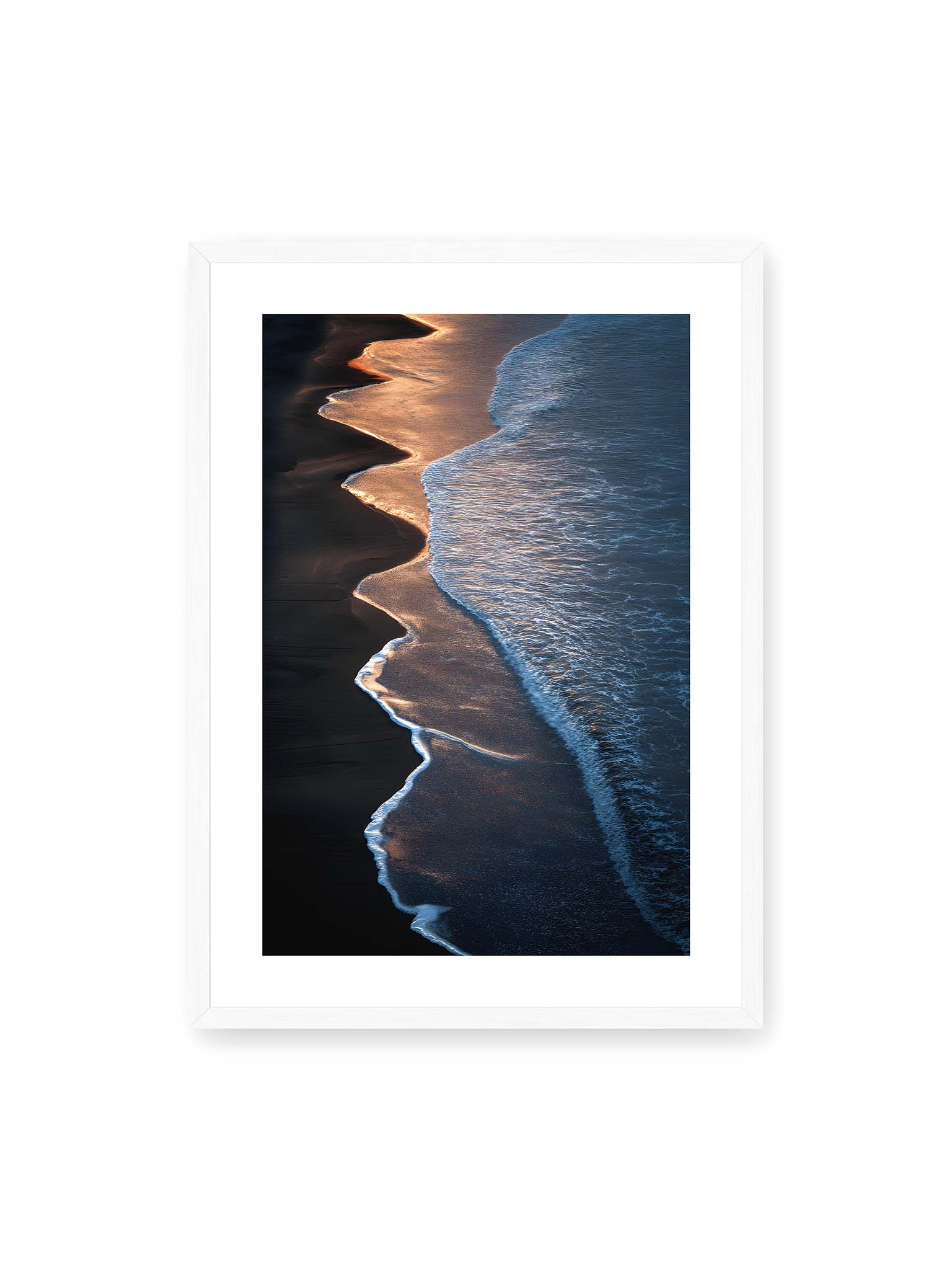 50x70 cm, weißer Galerie-Rand, weißer Rahmen – Goldene Wellenlinien treffen auf dunklen Strand mit starkem Kontrast zwischen Licht und Schatten entlang der Küste.