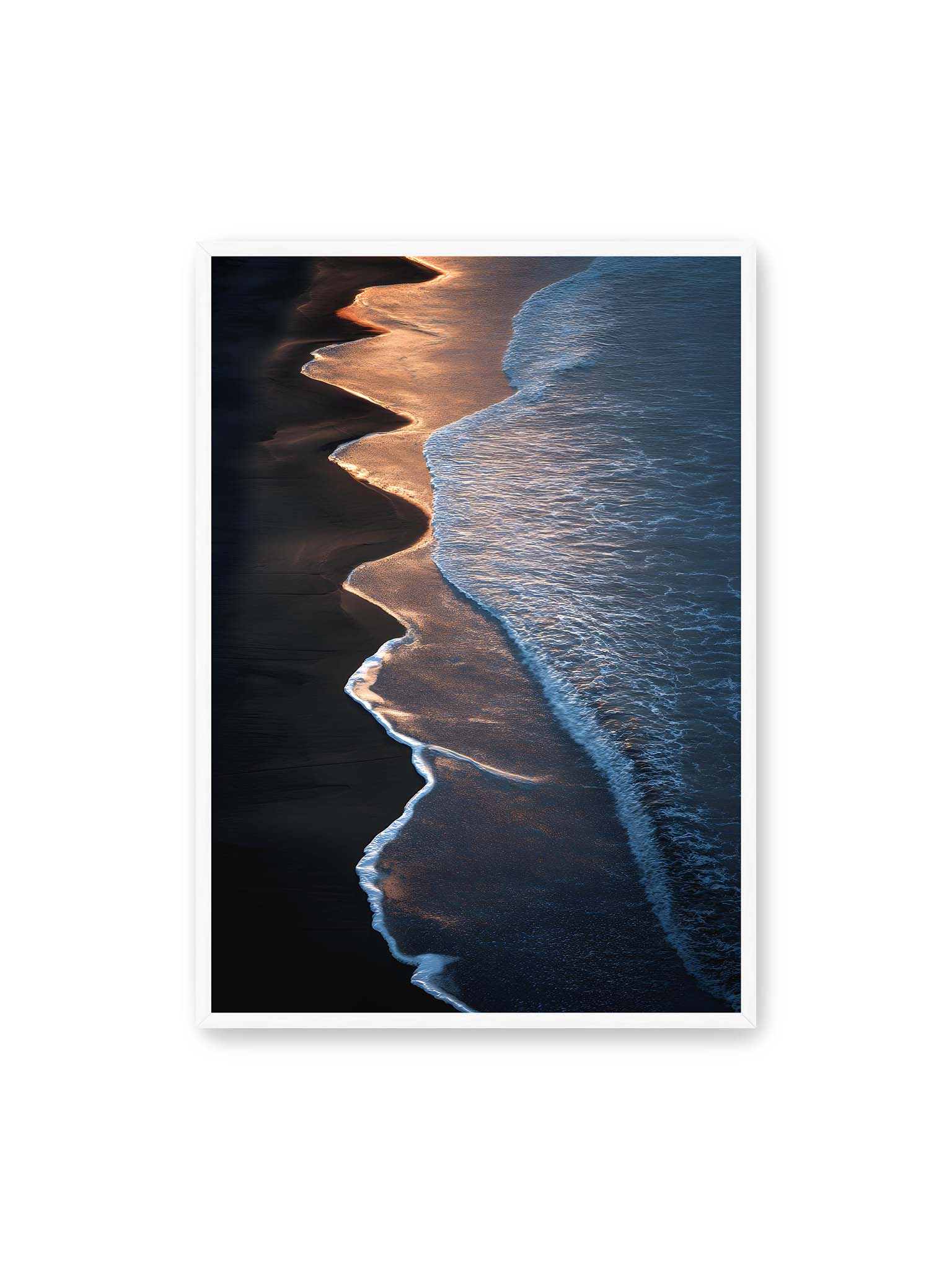70x100 cm, weißer Rahmen – Goldene Wellenlinien treffen auf dunklen Strand mit starkem Kontrast zwischen Licht und Schatten entlang der Küste.