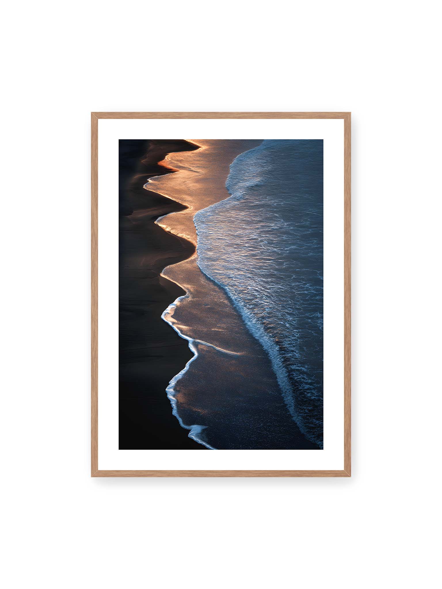 70x100 cm, weißer Galerie-Rand, Eichenrahmen – Goldene Wellenlinien treffen auf dunklen Strand mit starkem Kontrast zwischen Licht und Schatten entlang der Küste.