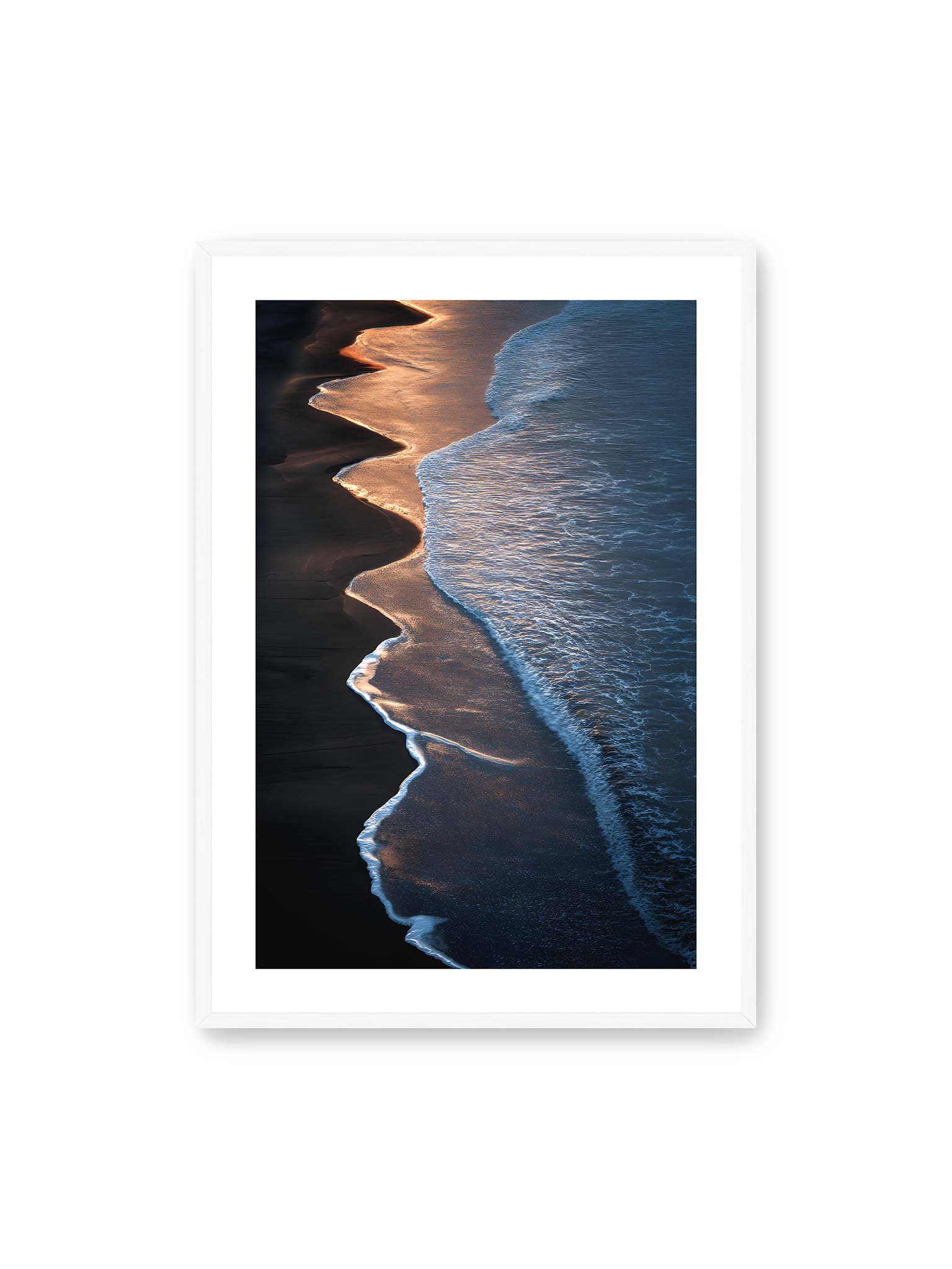 70x100 cm, weißer Galerie-Rand, weißer Rahmen – Goldene Wellenlinien treffen auf dunklen Strand mit starkem Kontrast zwischen Licht und Schatten entlang der Küste.