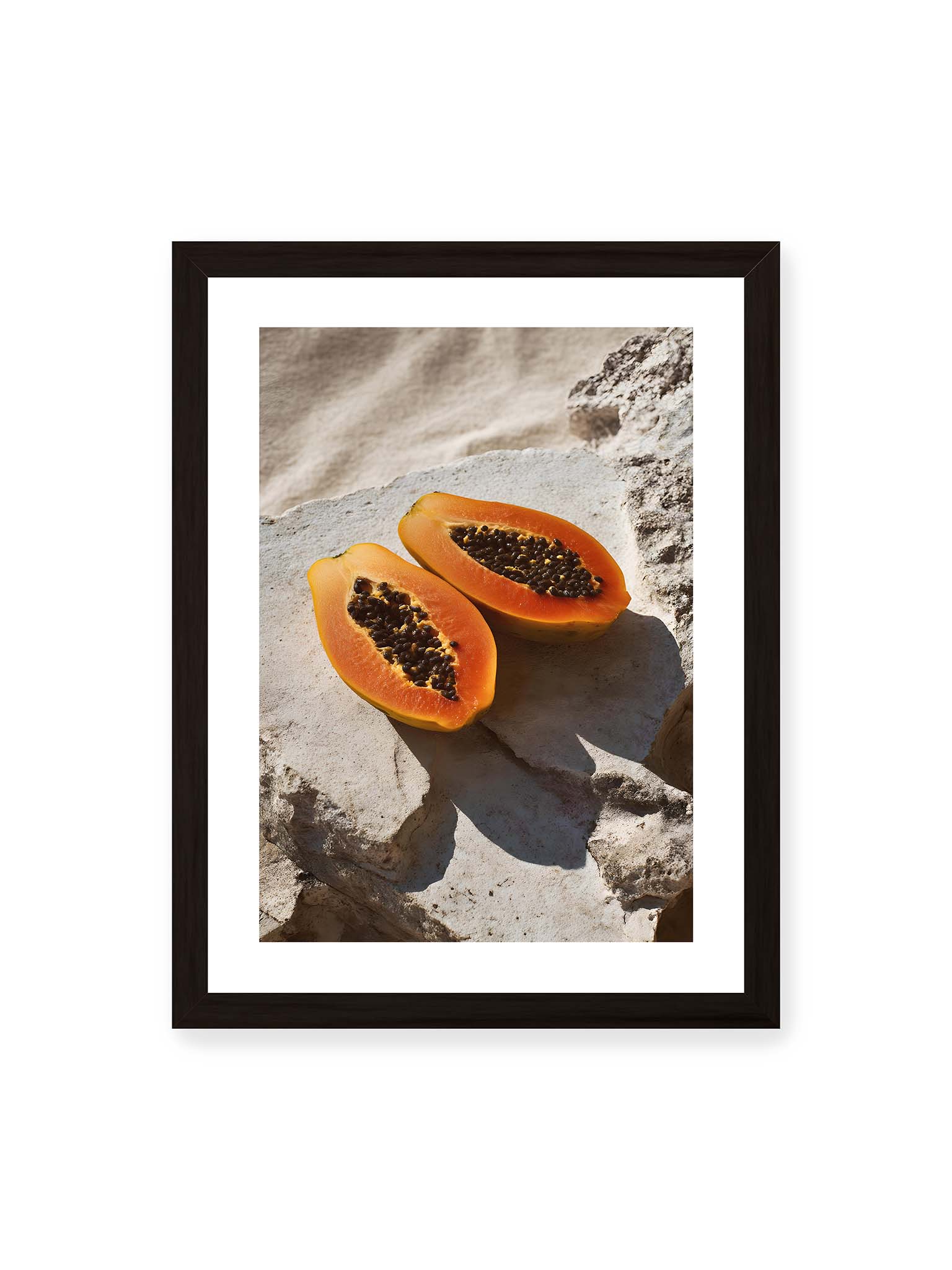 30x40 cm, weißer Galerie-Rand, schwarzer Rahmen – Zwei halbierte Papayas auf hellem Stein mit dunklen Kernen und leuchtend orangem Fruchtfleisch im direkten Licht.