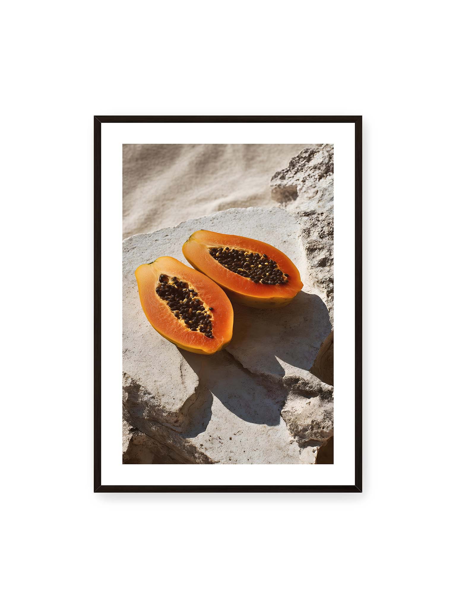 70x100 cm, weißer Galerie-Rand, schwarzer Rahmen – Zwei halbierte Papayas auf hellem Stein mit dunklen Kernen und leuchtend orangem Fruchtfleisch im direkten Licht.