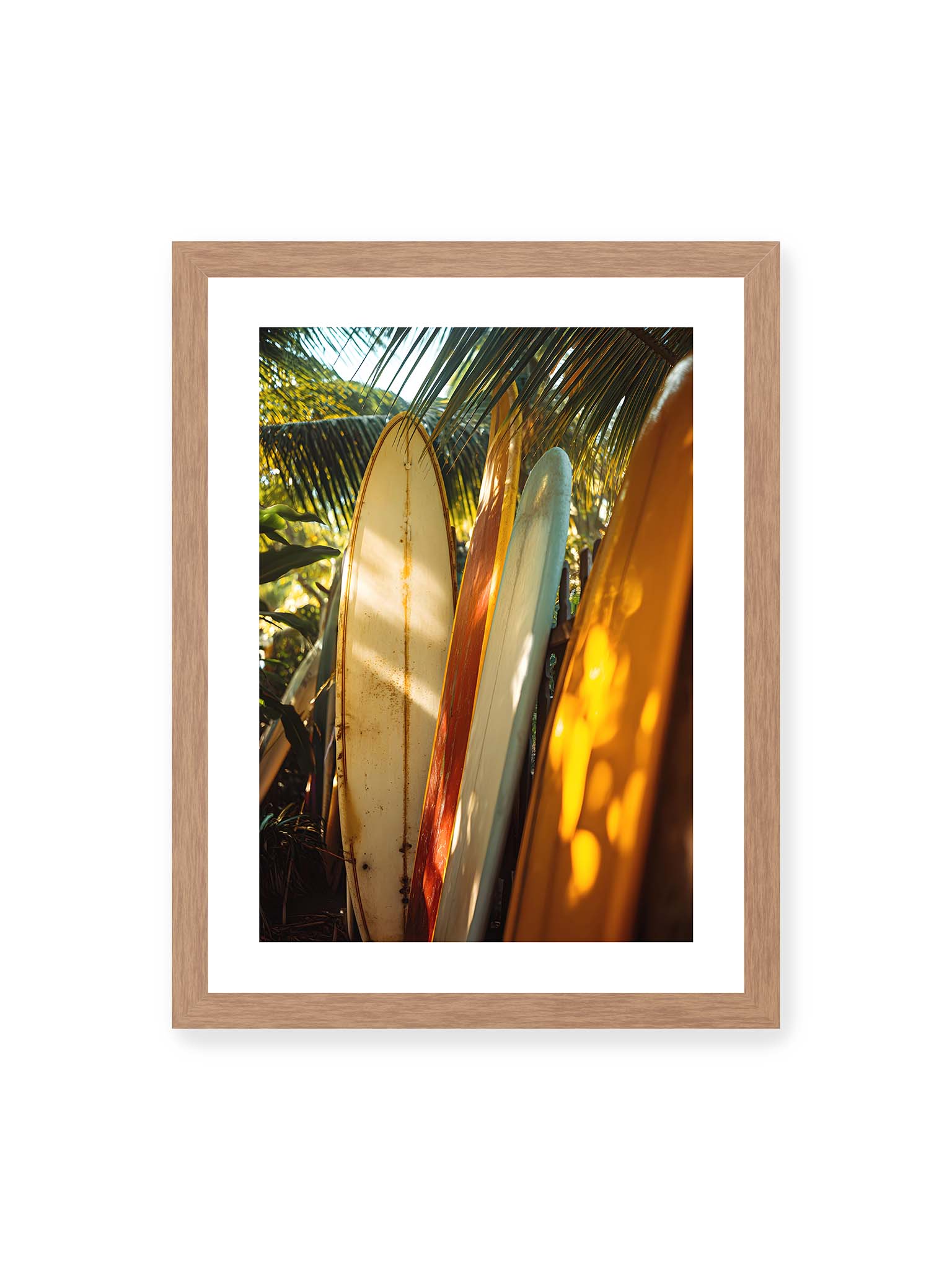 30x40 cm, weißer Galerie-Rand, Eichenrahmen – Mehrere Surfboards lehnen unter Palmen im warmen Licht mit Schatten und natürlichen Farben in tropischer Umgebung.