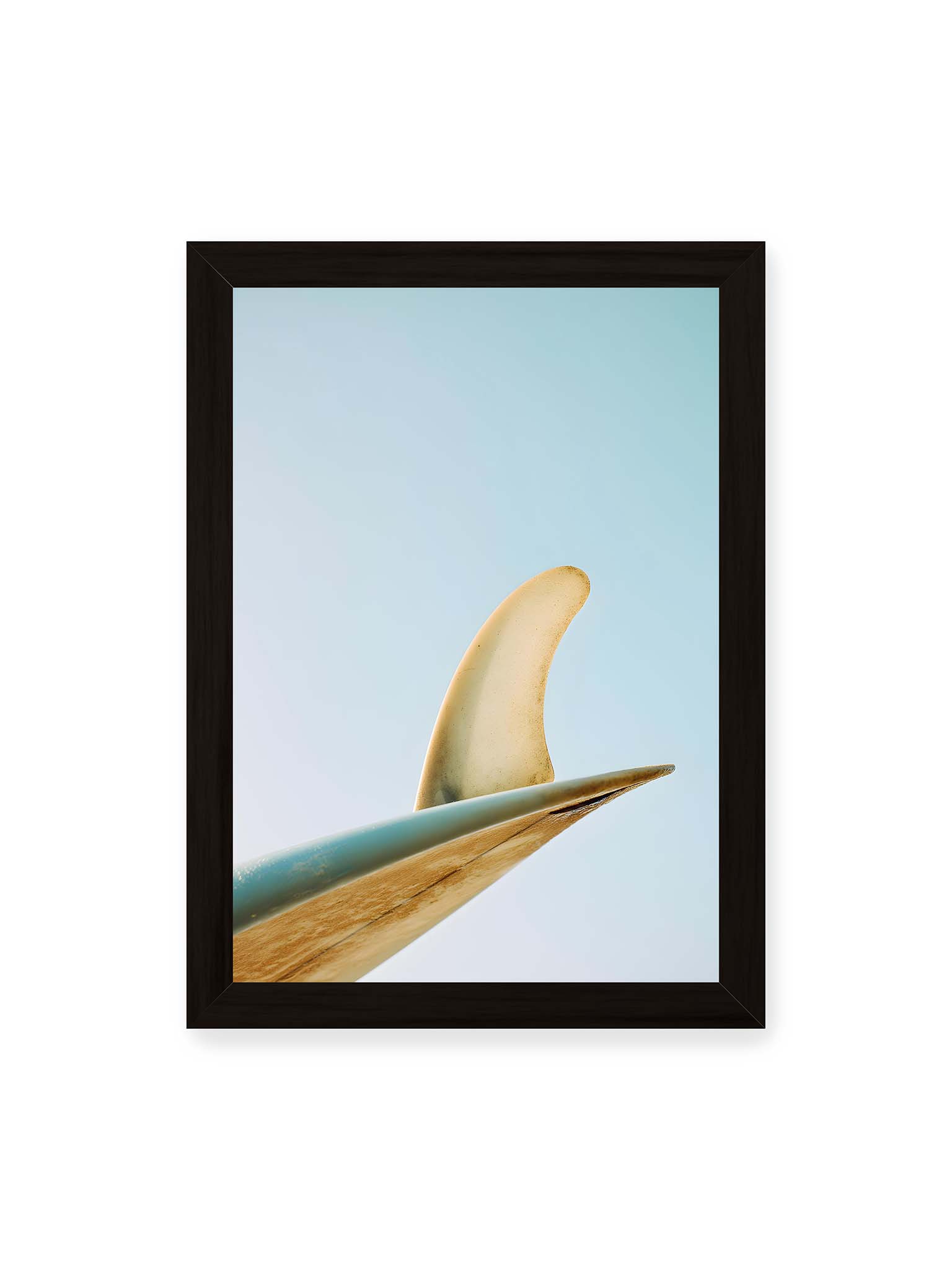 21x30 cm, schwarzer Rahmen – Surfboard-Finne vor klarem Himmel mit geschwungener Form und minimalistischer Komposition.