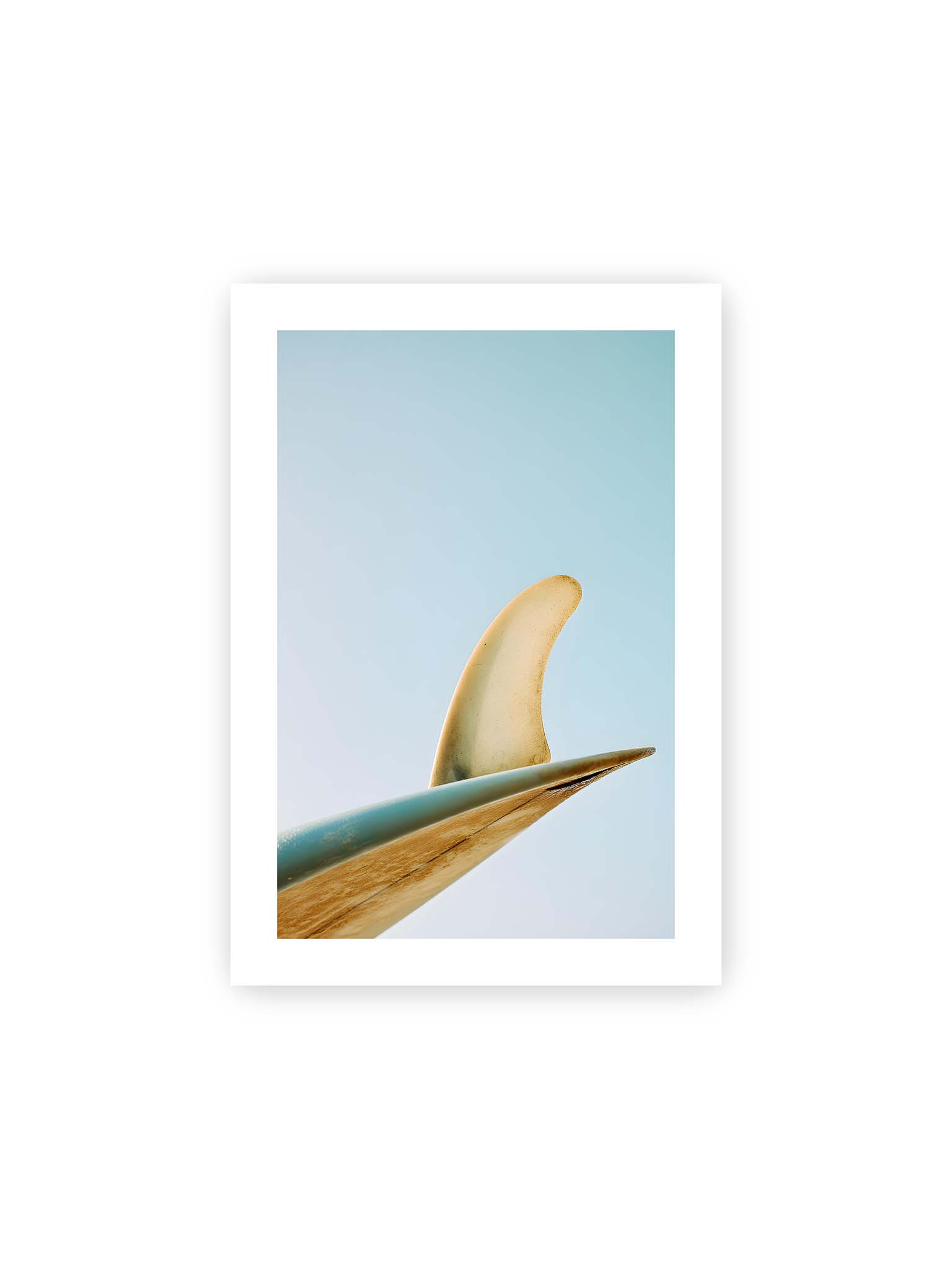 21x30 cm, weißer Galerie-Rand – Surfboard-Finne vor klarem Himmel mit geschwungener Form und minimalistischer Komposition.