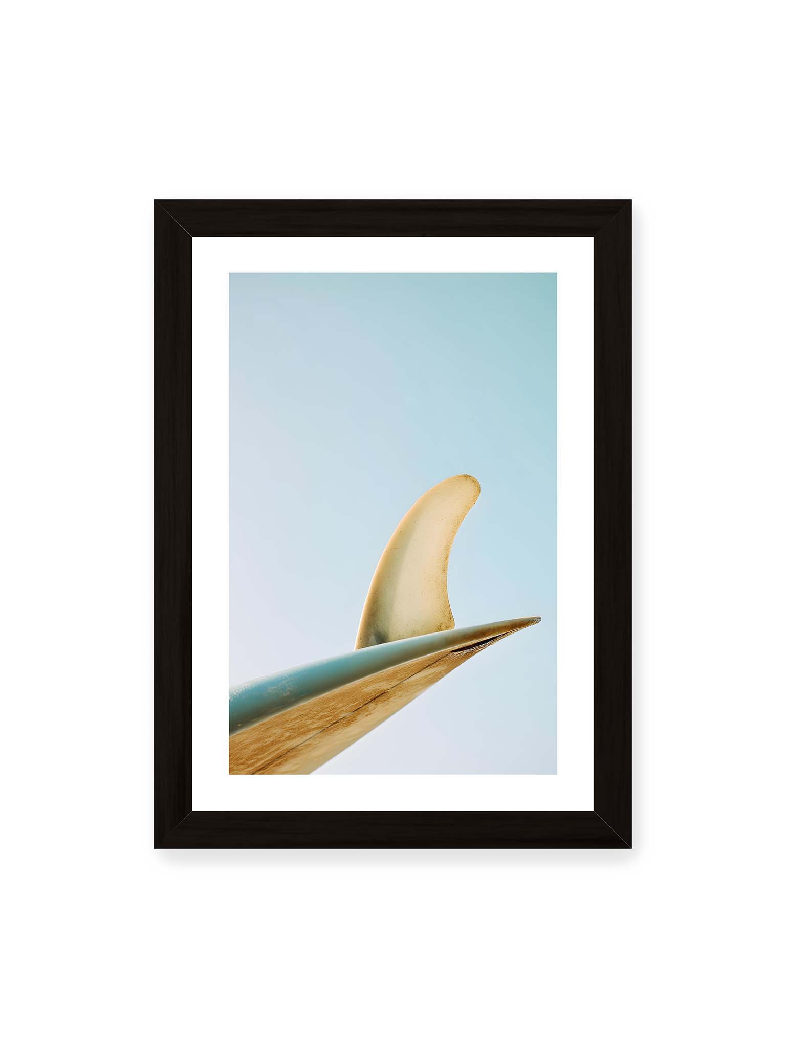 21x30 cm, weißer Galerie-Rand, schwarzer Rahmen – Surfboard-Finne vor klarem Himmel mit geschwungener Form und minimalistischer Komposition.