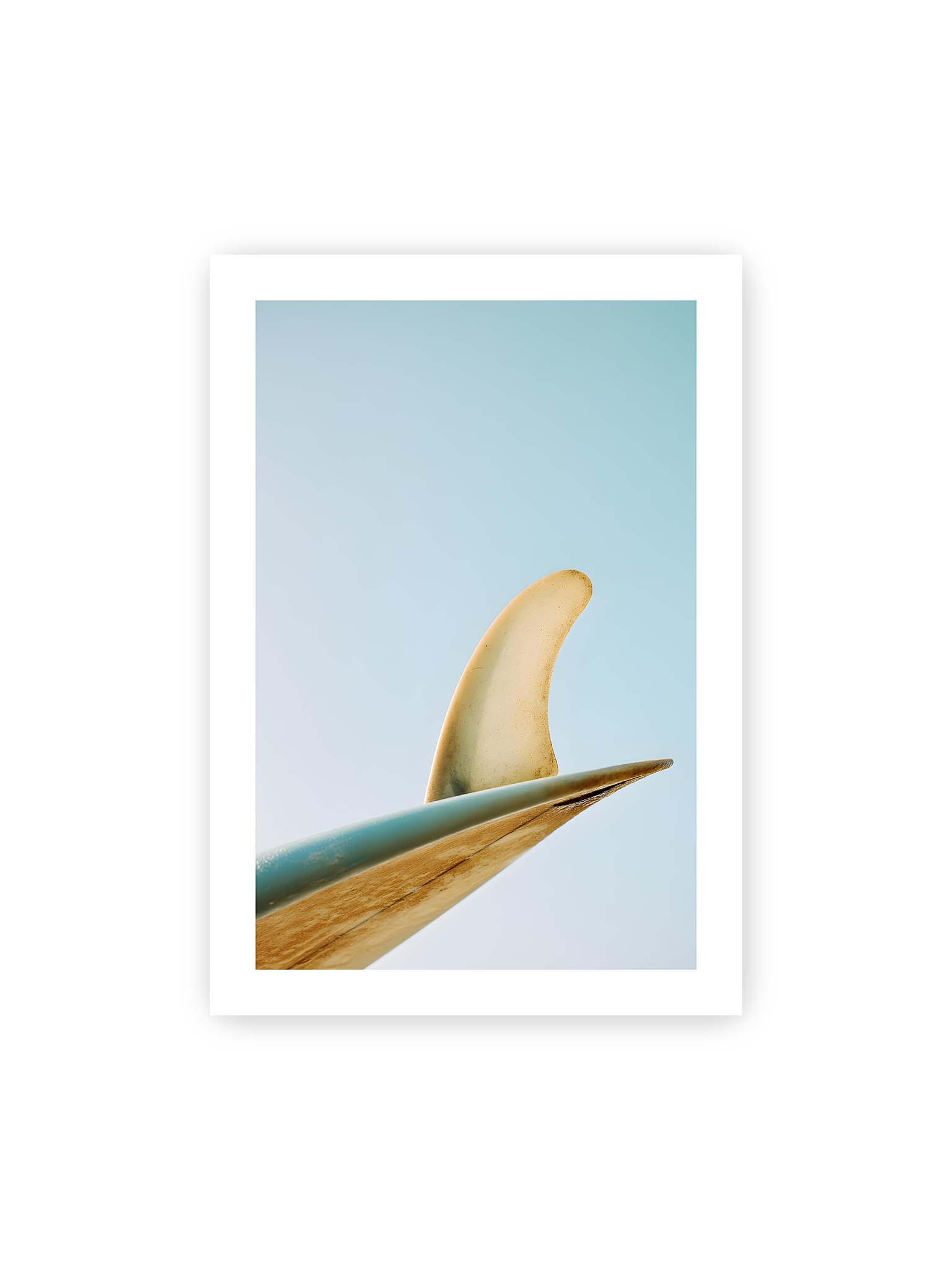 70x100 cm, weißer Galerie-Rand – Surfboard-Finne vor klarem Himmel mit geschwungener Form und minimalistischer Komposition.