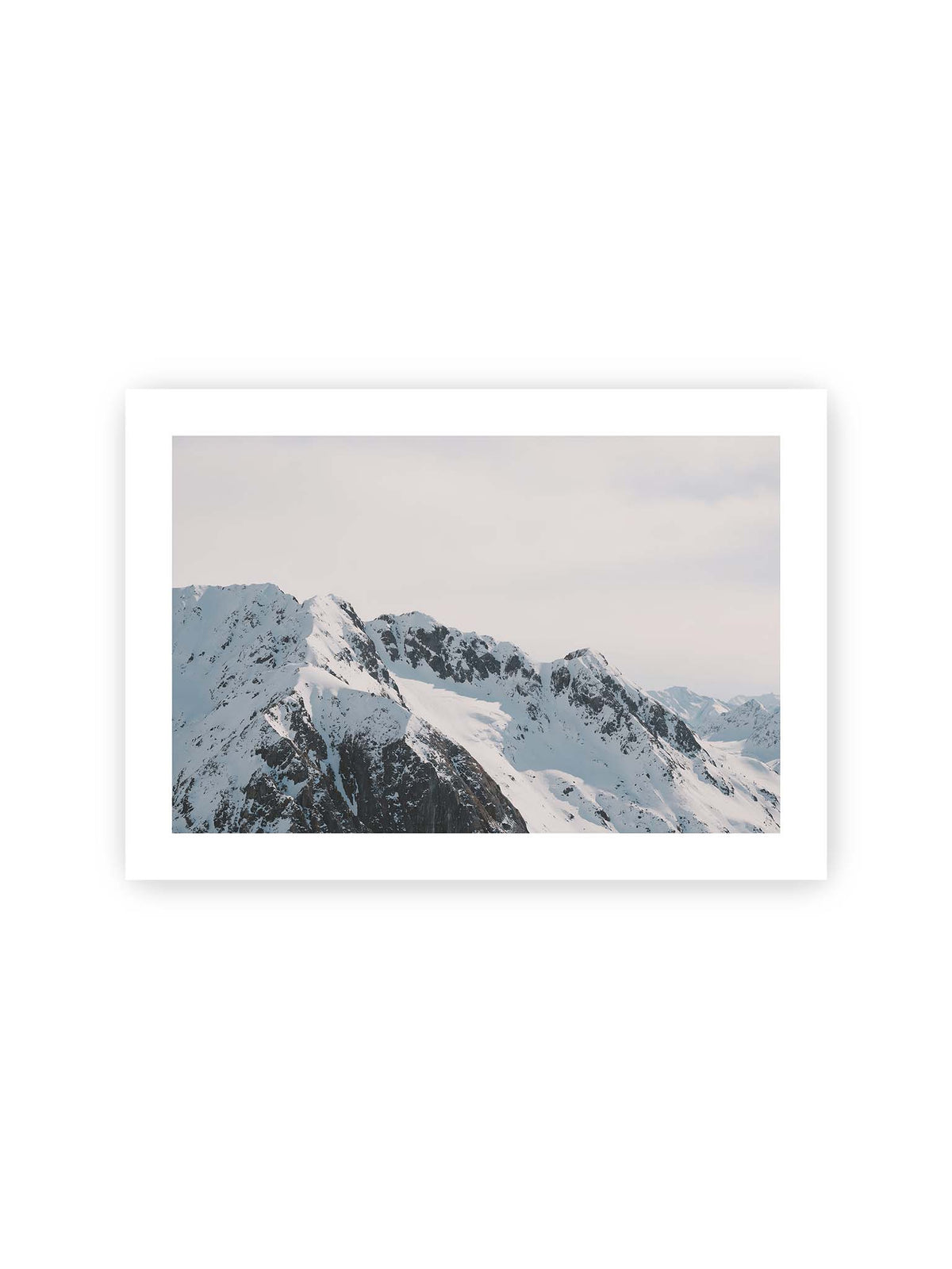 30x21 cm, weißer Galerie-Rand – Verschneite Bergkette mit schroffen Felswänden und gestaffelten Gipfeln unter einem hellen, weiten Himmel.