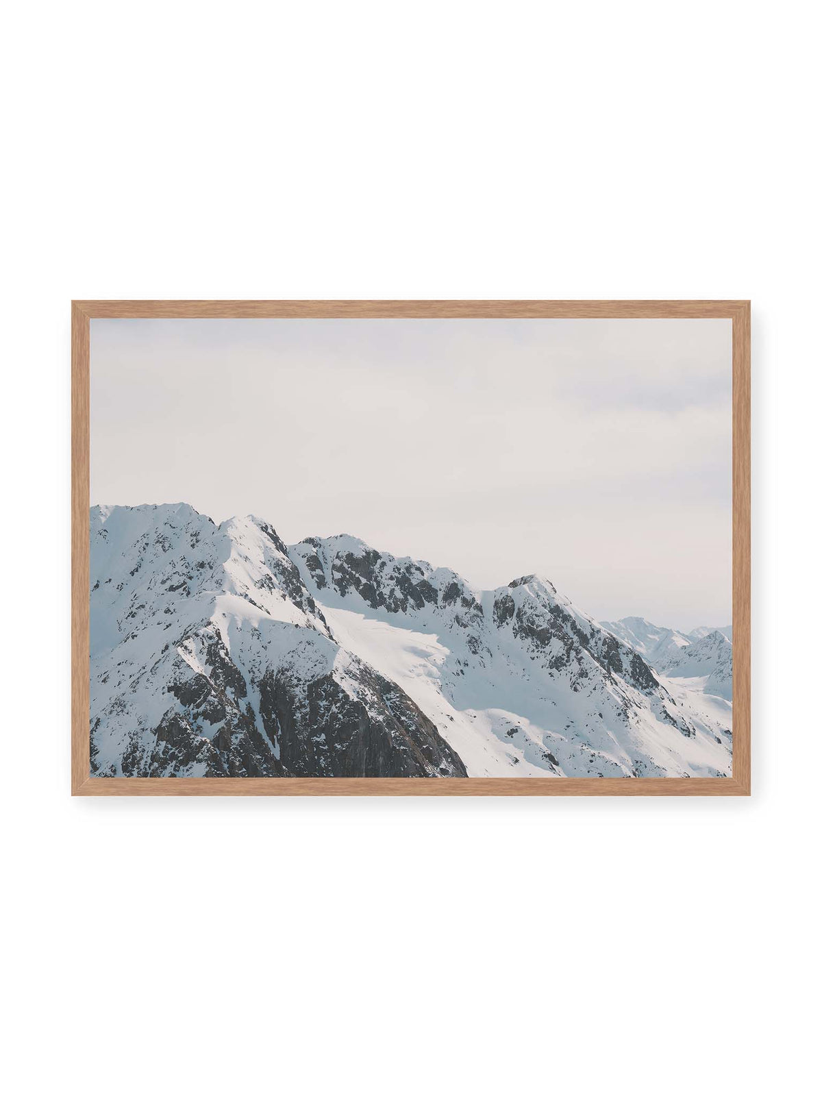 70x50 cm, Eichenrahmen – Verschneite Bergkette mit schroffen Felswänden und gestaffelten Gipfeln unter einem hellen, weiten Himmel.