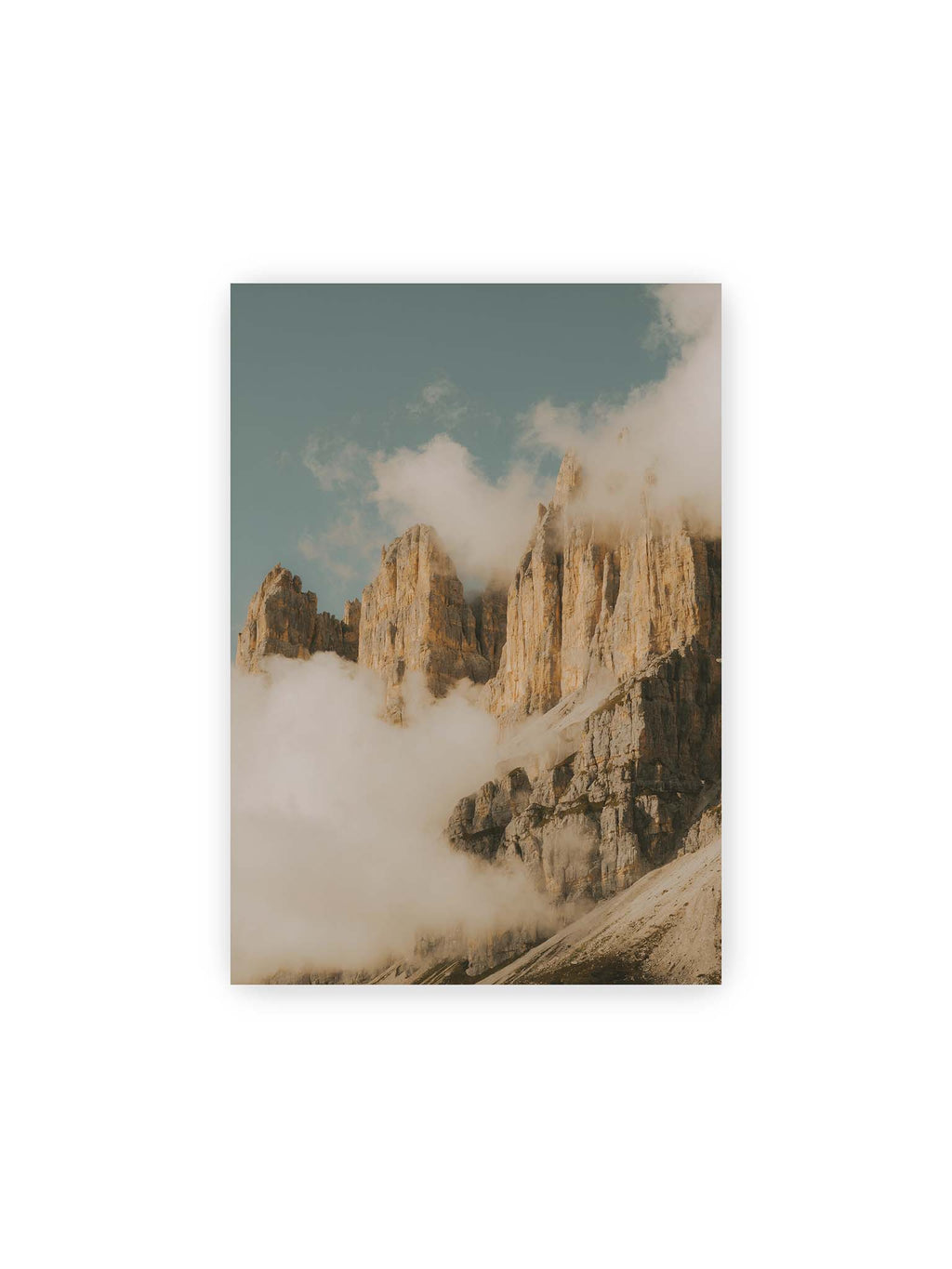 21x30 cm – Helle, zerklüftete Felsgipfel ragen aus dichten Wolken vor einem blassblauen Himmel.