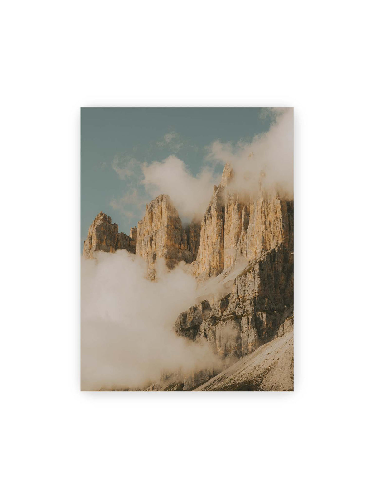 30x40 cm – Helle, zerklüftete Felsgipfel ragen aus dichten Wolken vor einem blassblauen Himmel.