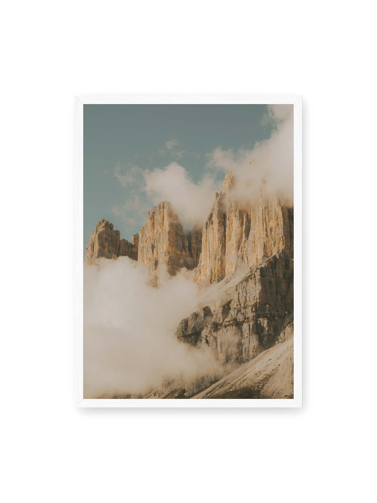 50x70 cm, weißer Rahmen – Helle, zerklüftete Felsgipfel ragen aus dichten Wolken vor einem blassblauen Himmel.