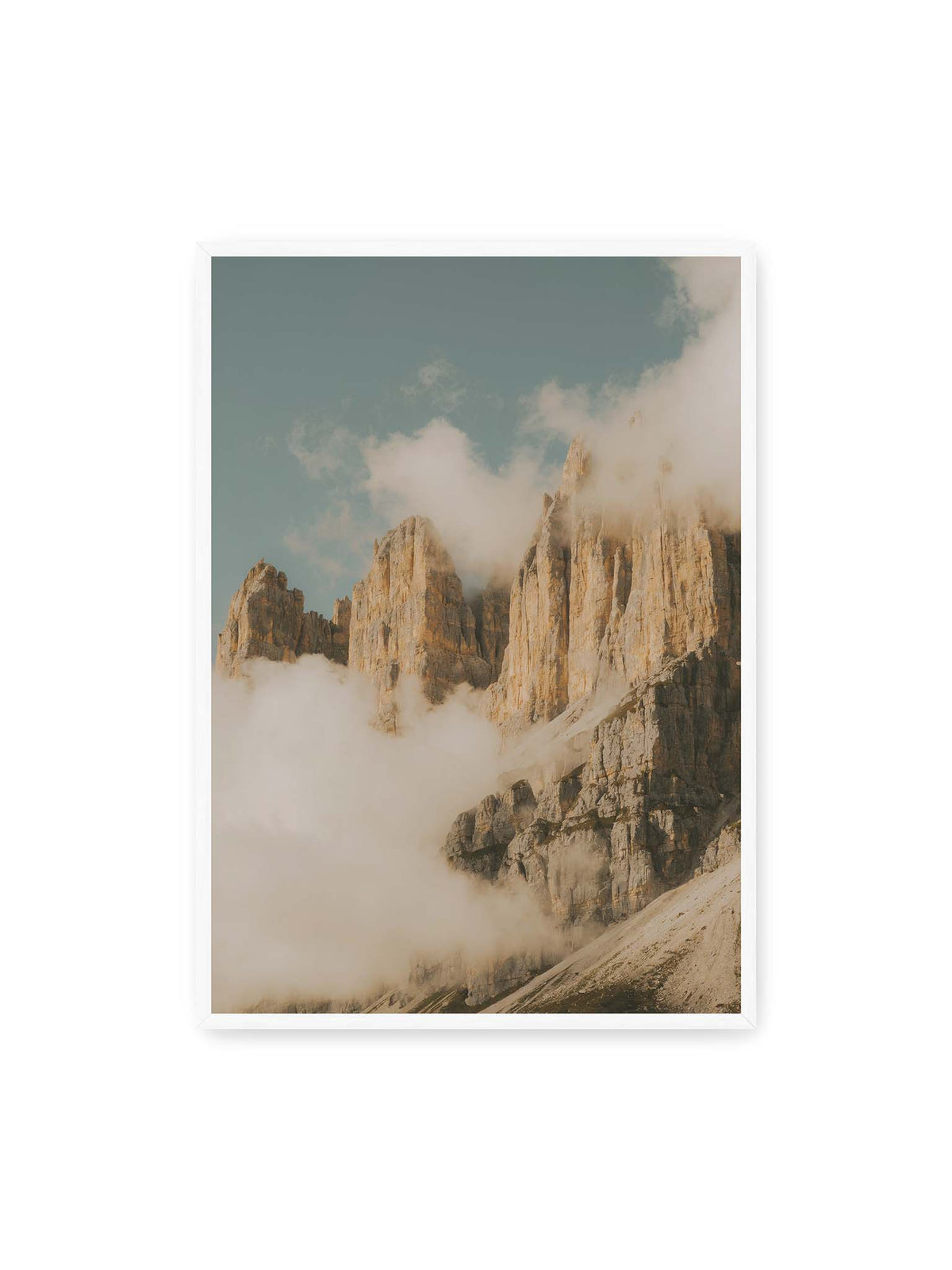 70x100 cm, weißer Rahmen – Helle, zerklüftete Felsgipfel ragen aus dichten Wolken vor einem blassblauen Himmel.
