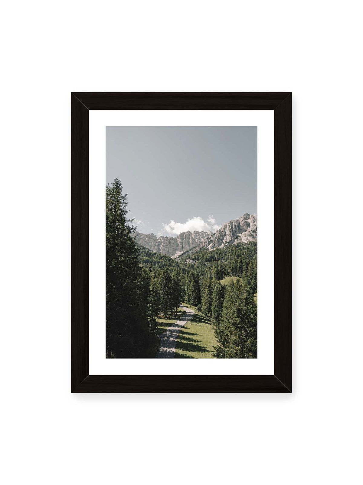 21x30 cm, weißer Galerie-Rand, schwarzer Rahmen – Kurviger Weg durch dichten Nadelwald mit hellen, schroffen Felsformationen im Hintergrund.