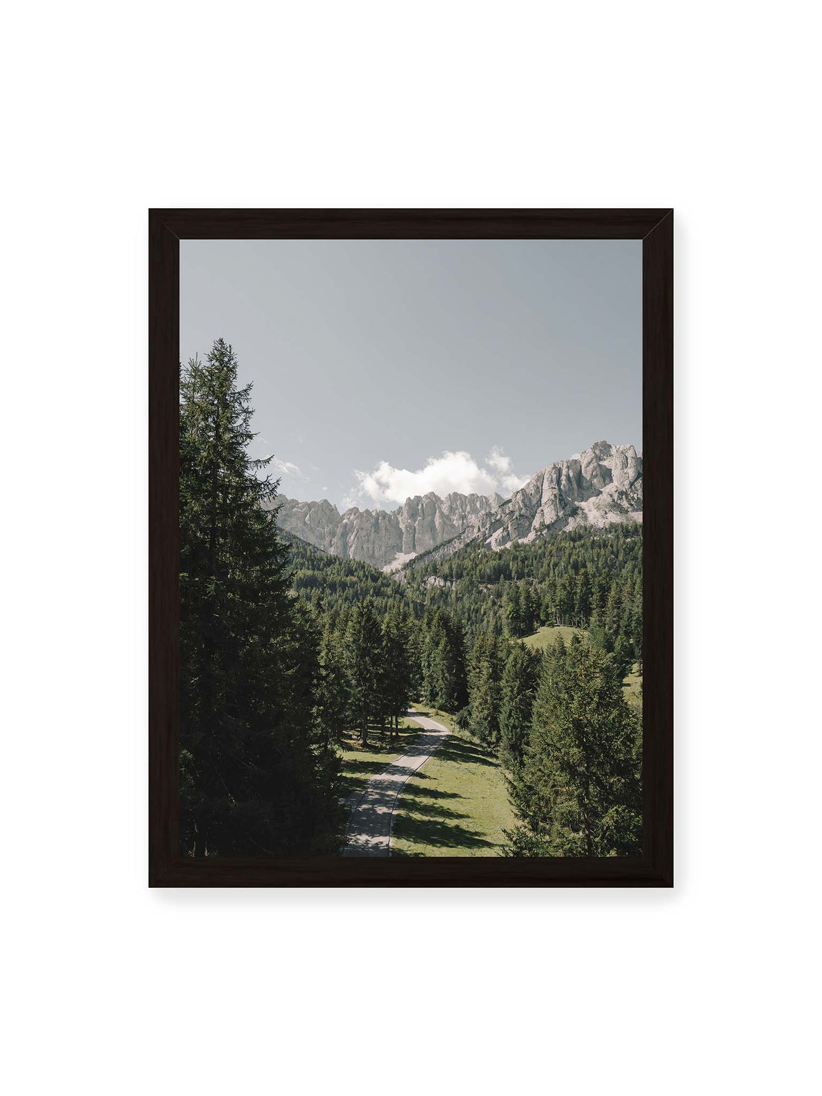 30x40 cm, schwarzer Rahmen – Kurviger Weg durch dichten Nadelwald mit hellen, schroffen Felsformationen im Hintergrund.