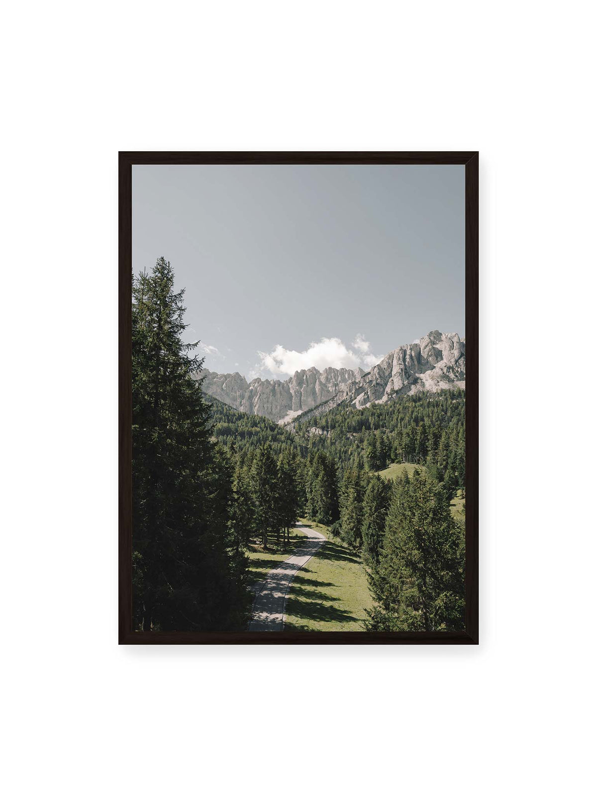 50x70 cm, schwarzer Rahmen – Kurviger Weg durch dichten Nadelwald mit hellen, schroffen Felsformationen im Hintergrund.