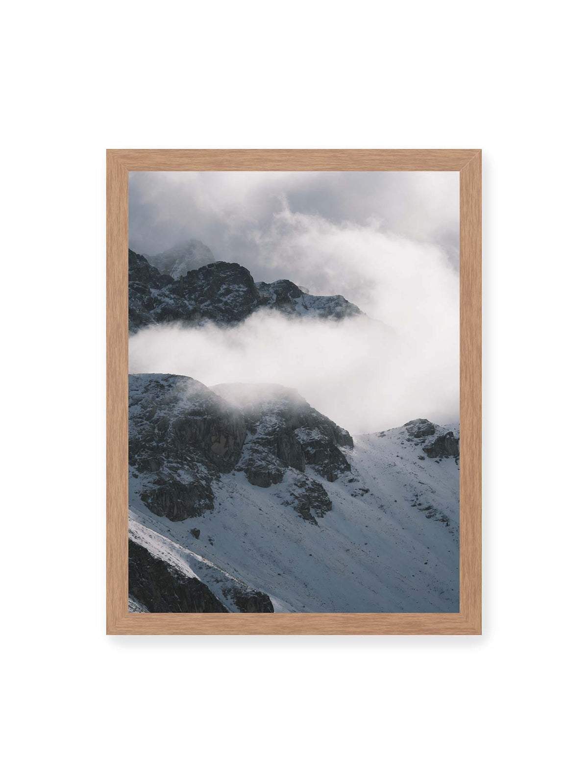 30x40 cm, Eichenrahmen – Verschneite dunkle Felsrücken ragen zwischen dichten, tief ziehenden Wolken hervor.
