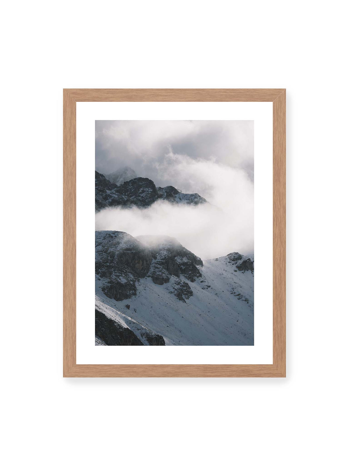 30x40 cm, weißer Galerie-Rand, Eichenrahmen – Verschneite dunkle Felsrücken ragen zwischen dichten, tief ziehenden Wolken hervor.