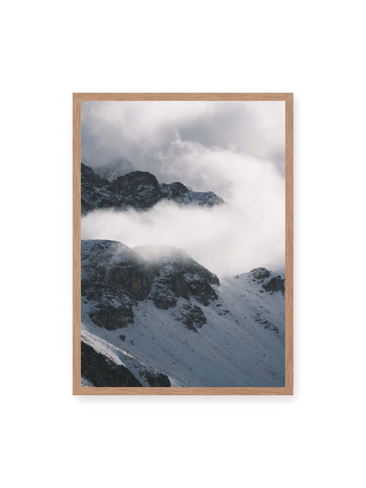 50x70 cm, Eichenrahmen – Verschneite dunkle Felsrücken ragen zwischen dichten, tief ziehenden Wolken hervor.
