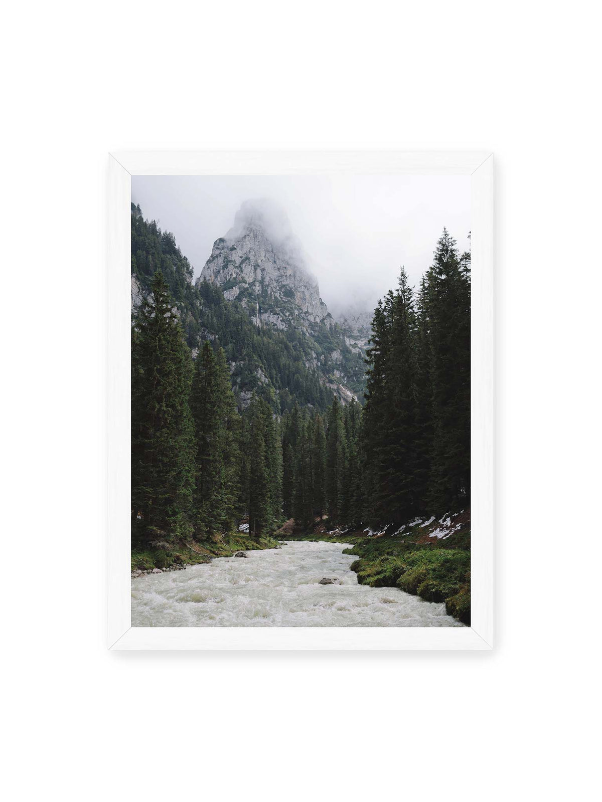 30x40 cm, weißer Rahmen – Heller Gebirgsfluss zwischen dichtem Nadelwald und steilen, von Wolken verhüllten Felsen.