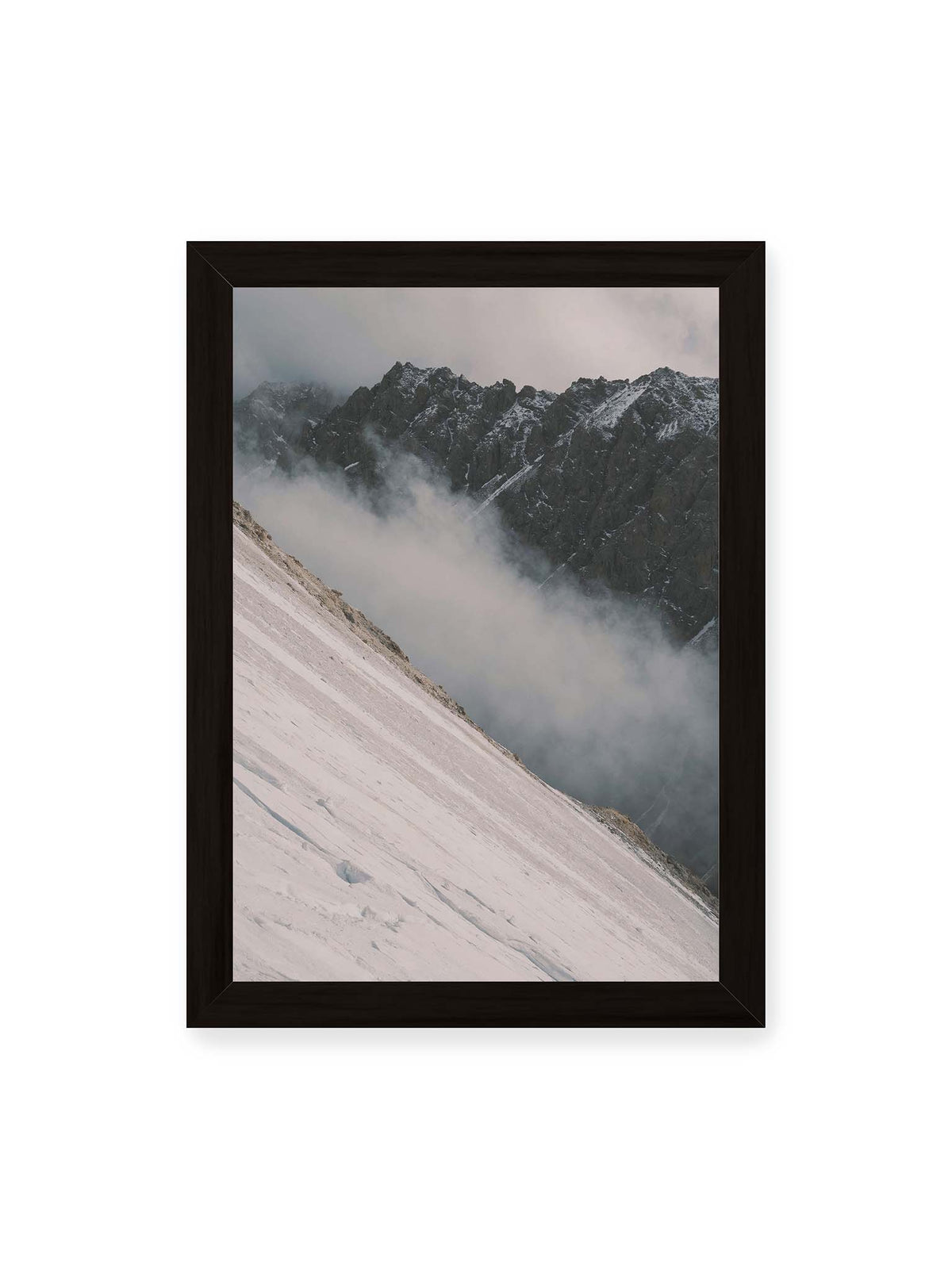 21x30 cm, schwarzer Rahmen – Diagonale Schneefläche vor dunkler Felswand, durchzogen von tief liegenden Wolken.
