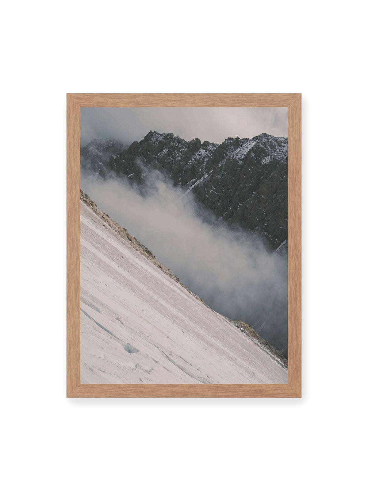 30x40 cm, Eichenrahmen – Diagonale Schneefläche vor dunkler Felswand, durchzogen von tief liegenden Wolken.