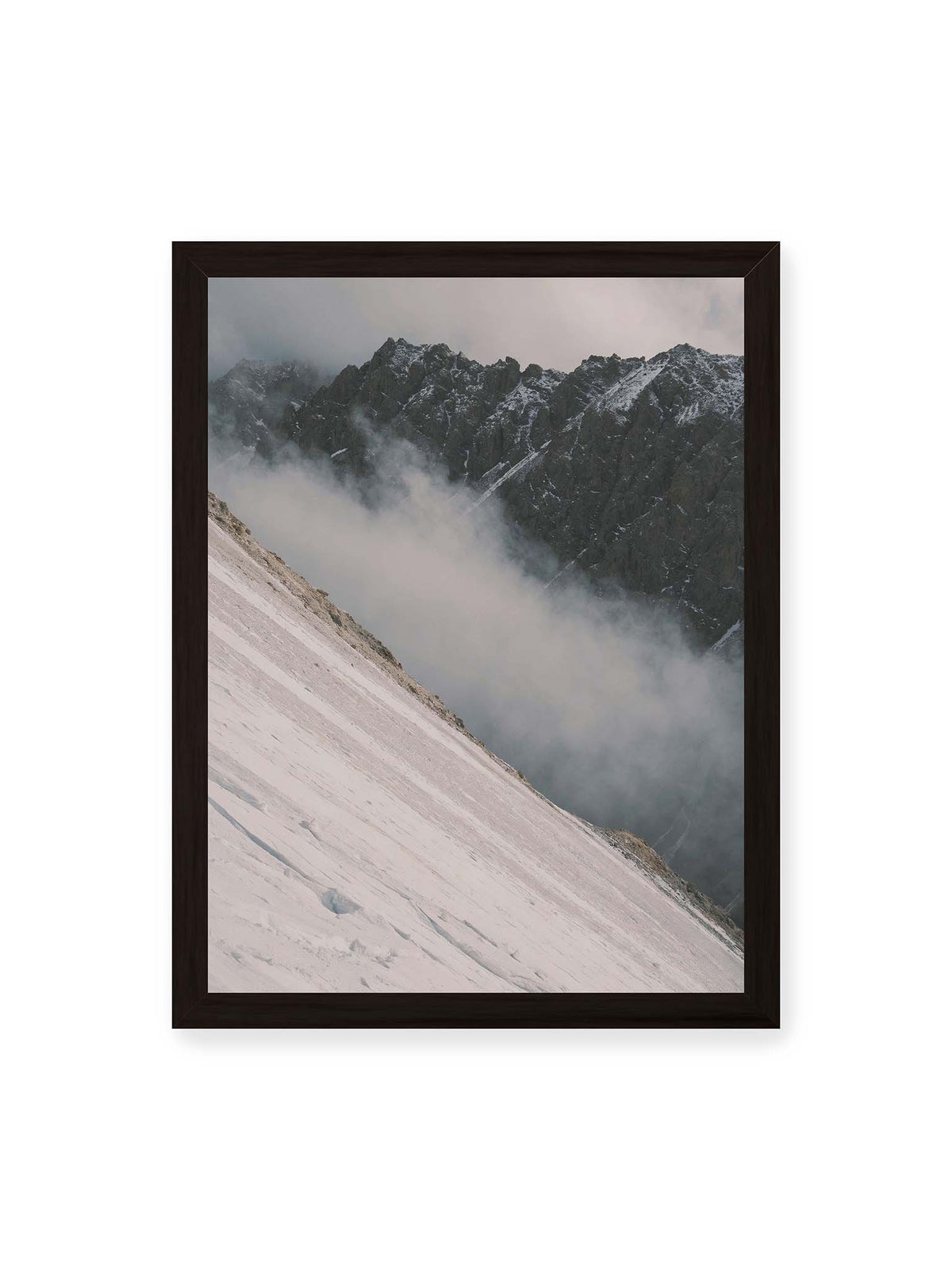 30x40 cm, schwarzer Rahmen – Diagonale Schneefläche vor dunkler Felswand, durchzogen von tief liegenden Wolken.