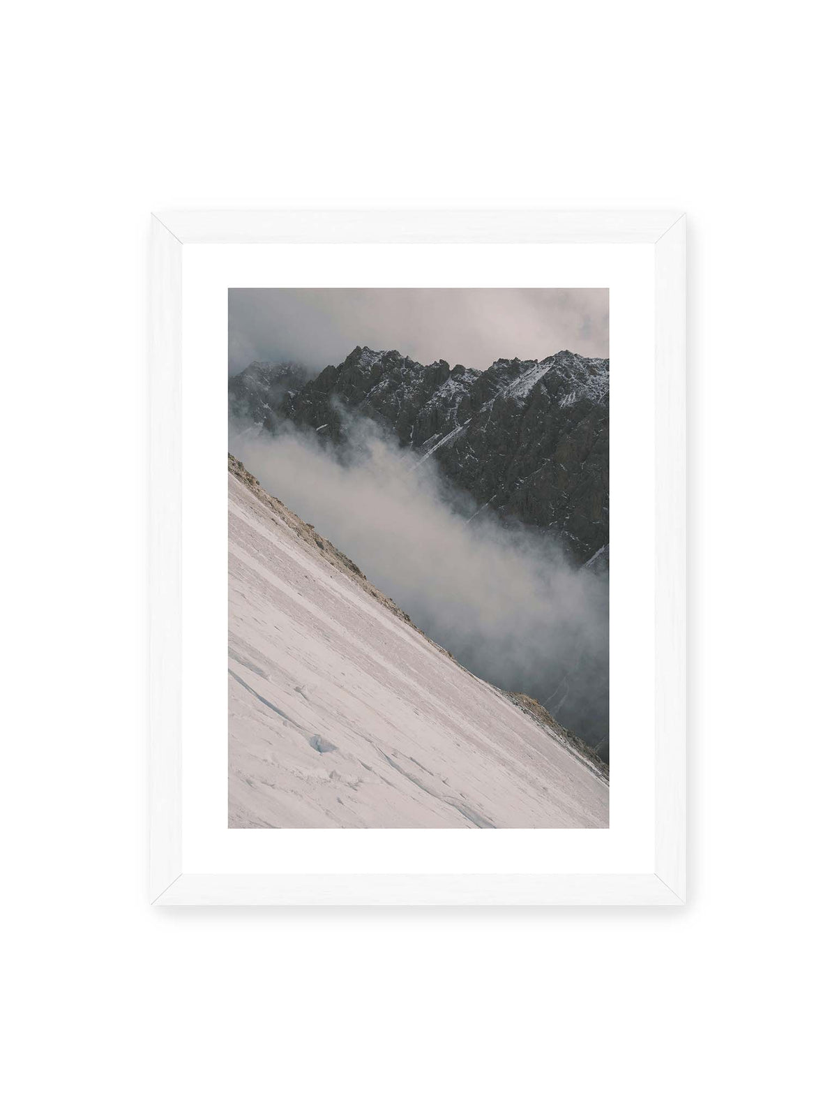 30x40 cm, weißer Galerie-Rand, weißer Rahmen – Diagonale Schneefläche vor dunkler Felswand, durchzogen von tief liegenden Wolken.