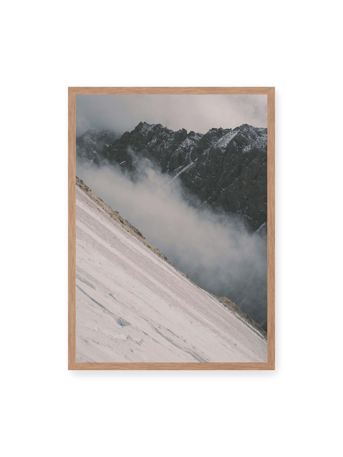 50x70 cm, Eichenrahmen – Diagonale Schneefläche vor dunkler Felswand, durchzogen von tief liegenden Wolken.