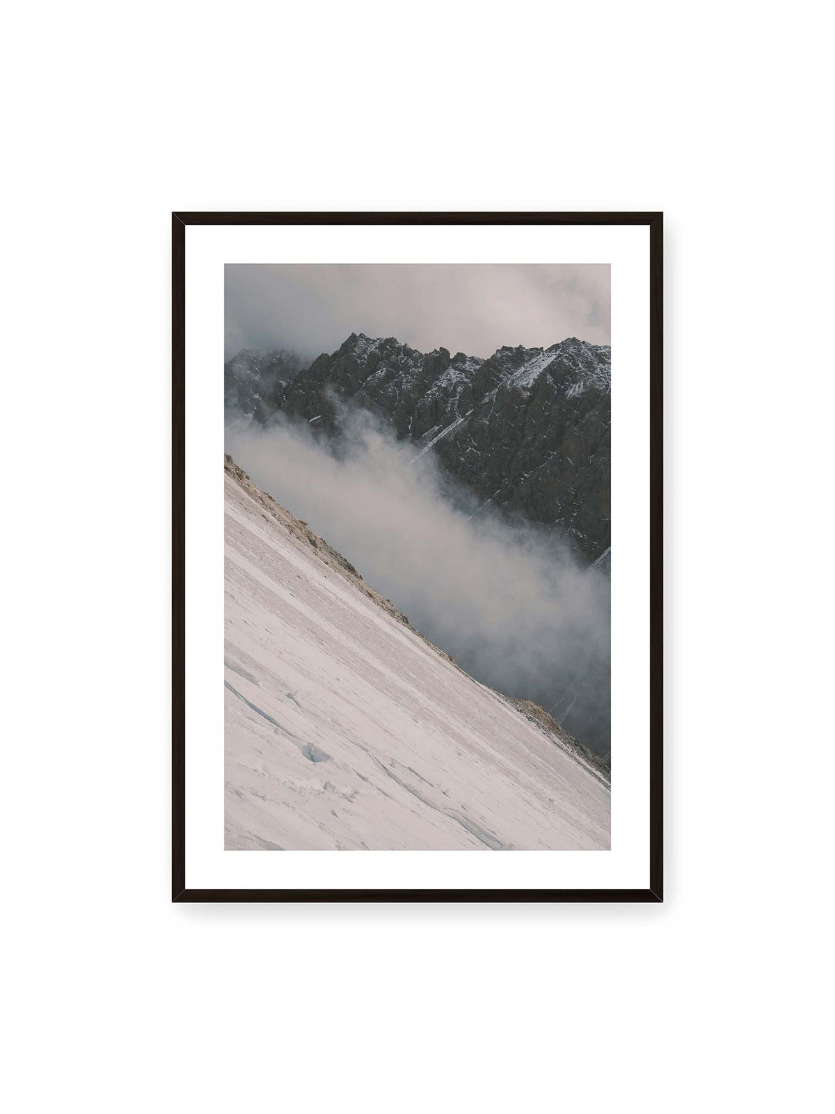 70x100 cm, weißer Galerie-Rand, schwarzer Rahmen – Diagonale Schneefläche vor dunkler Felswand, durchzogen von tief liegenden Wolken.