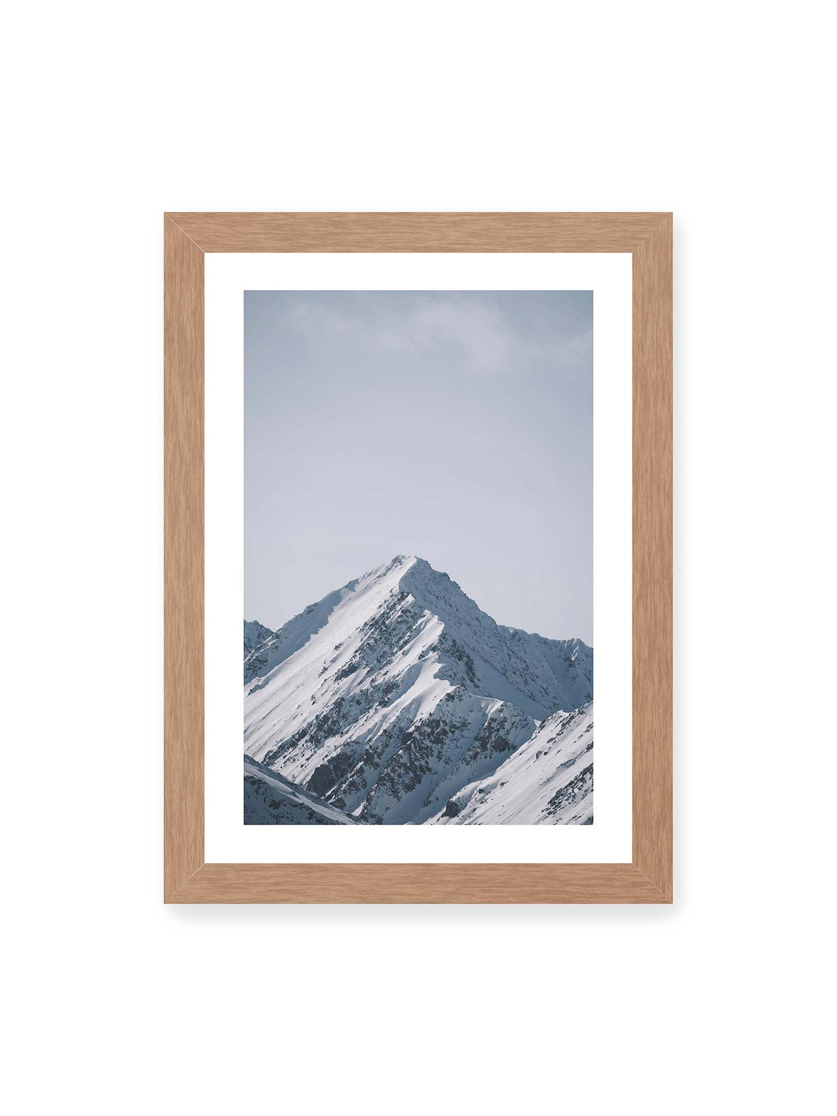 21x30 cm, weißer Galerie-Rand, Eichenrahmen – Schneebedeckter Berggipfel mit steilen Graten vor einem weiten blassblauen Himmel.
