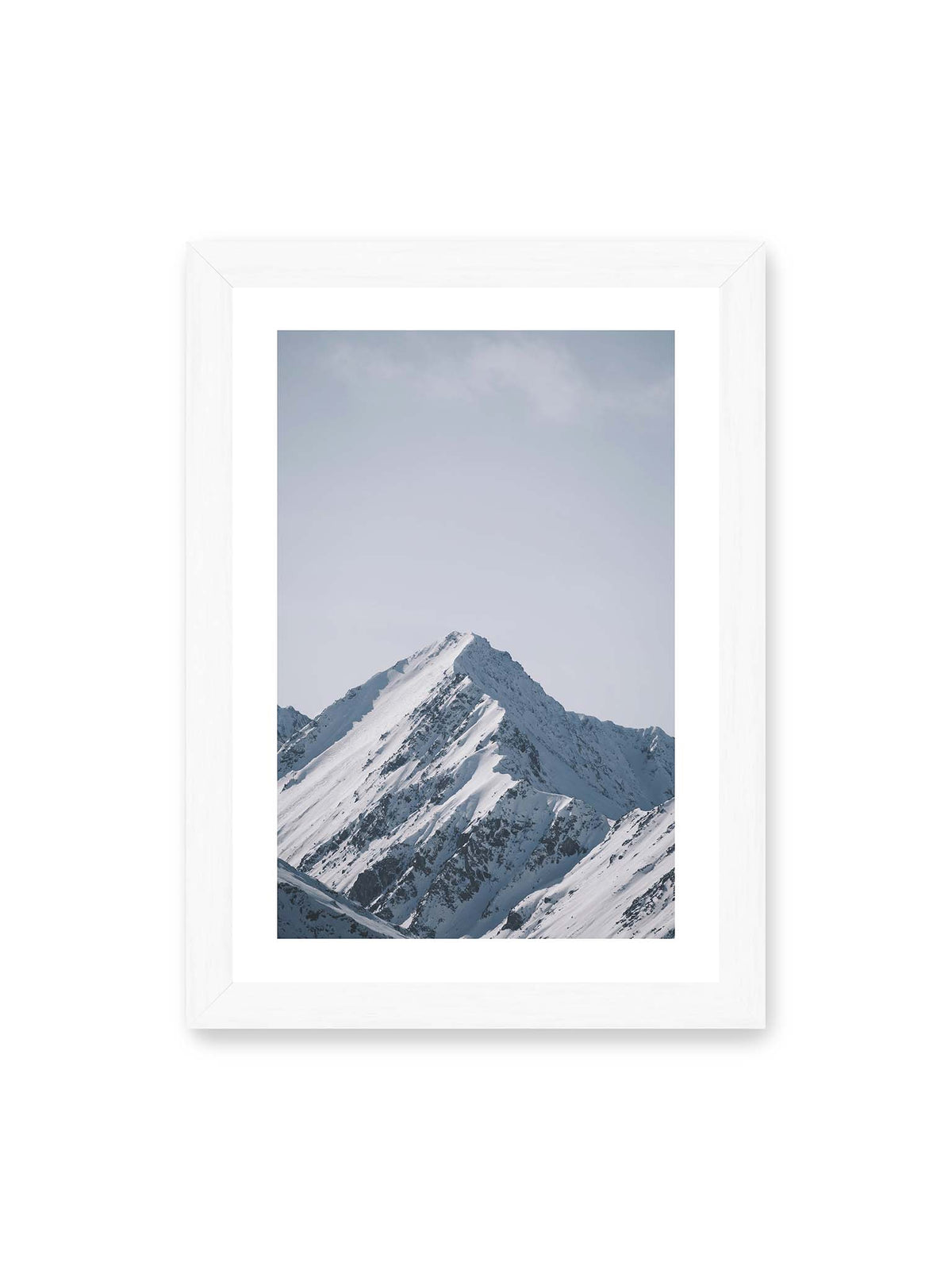 21x30 cm, weißer Galerie-Rand, weißer Rahmen – Schneebedeckter Berggipfel mit steilen Graten vor einem weiten blassblauen Himmel.