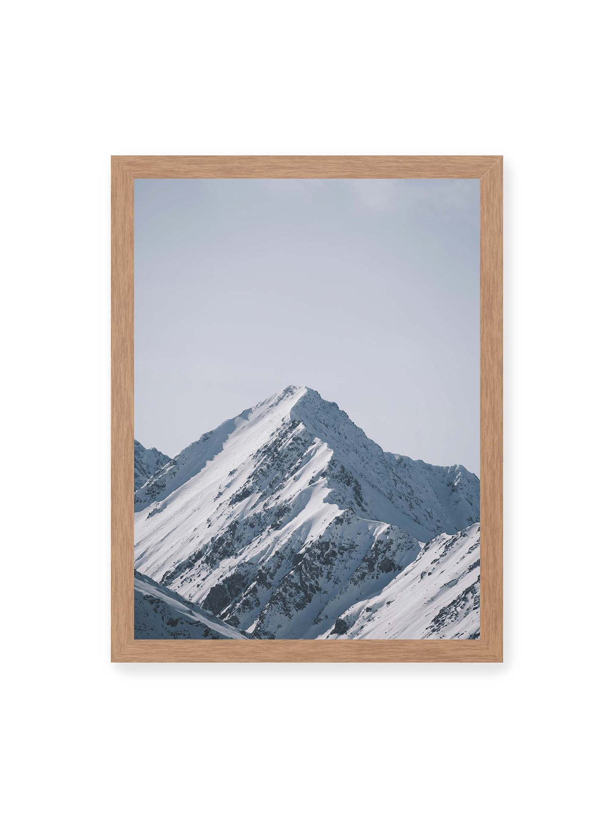 30x40 cm, Eichenrahmen – Schneebedeckter Berggipfel mit steilen Graten vor einem weiten blassblauen Himmel.