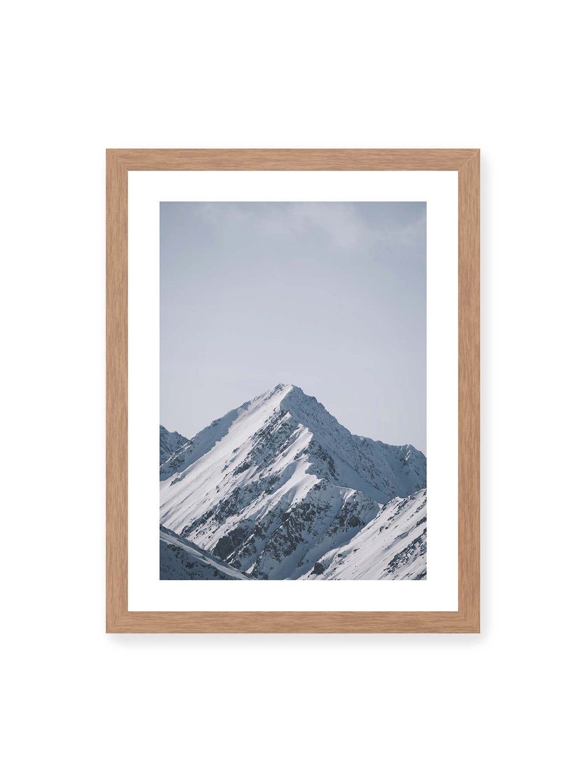 30x40 cm, weißer Galerie-Rand, Eichenrahmen – Schneebedeckter Berggipfel mit steilen Graten vor einem weiten blassblauen Himmel.