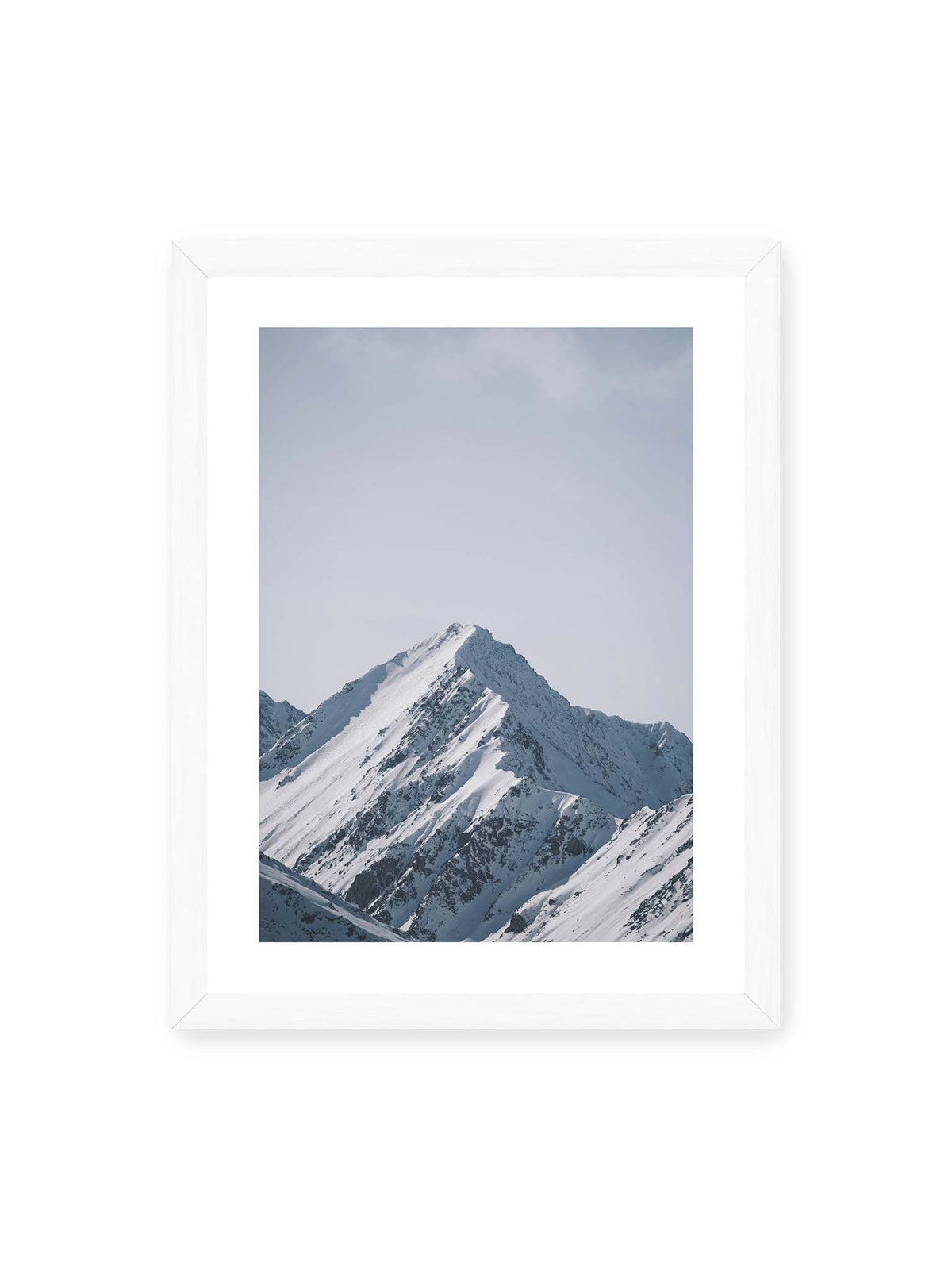 30x40 cm, weißer Galerie-Rand, weißer Rahmen – Schneebedeckter Berggipfel mit steilen Graten vor einem weiten blassblauen Himmel.