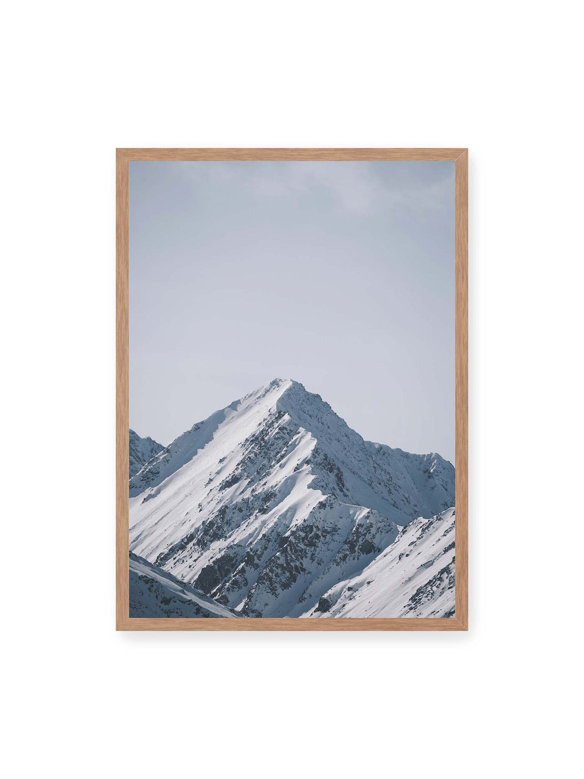 50x70 cm, Eichenrahmen – Schneebedeckter Berggipfel mit steilen Graten vor einem weiten blassblauen Himmel.