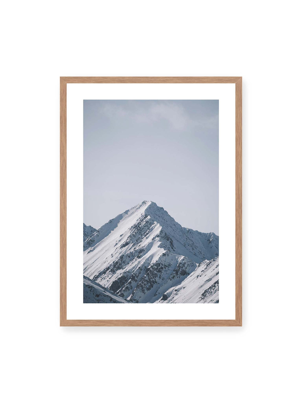50x70 cm, weißer Galerie-Rand, Eichenrahmen – Schneebedeckter Berggipfel mit steilen Graten vor einem weiten blassblauen Himmel.