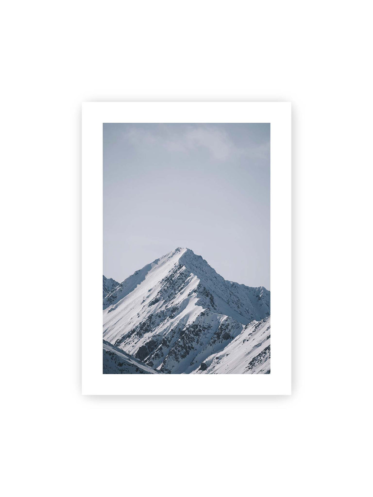 50x70 cm, weißer Galerie-Rand – Schneebedeckter Berggipfel mit steilen Graten vor einem weiten blassblauen Himmel.