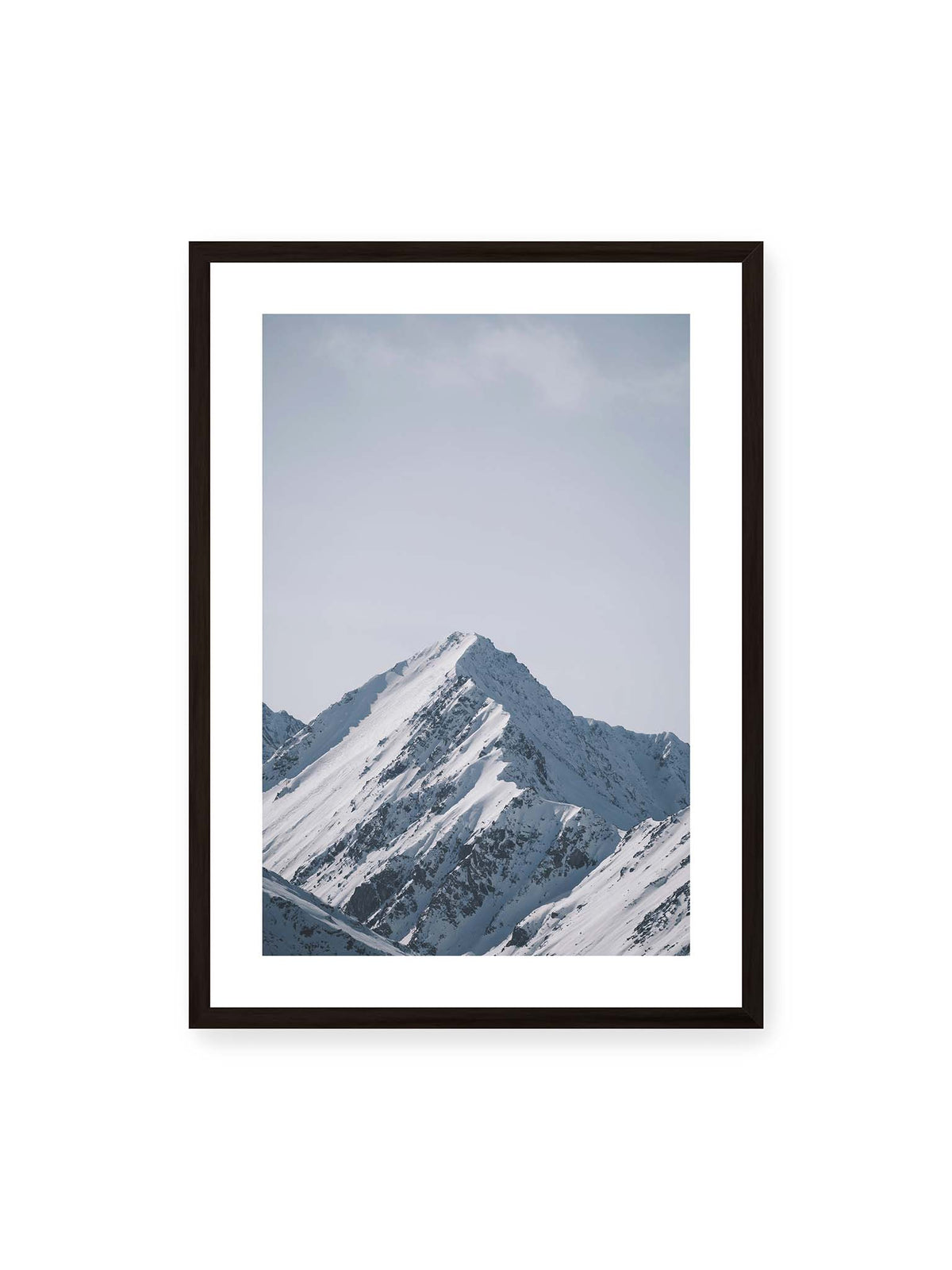 50x70 cm, weißer Galerie-Rand, schwarzer Rahmen – Schneebedeckter Berggipfel mit steilen Graten vor einem weiten blassblauen Himmel.