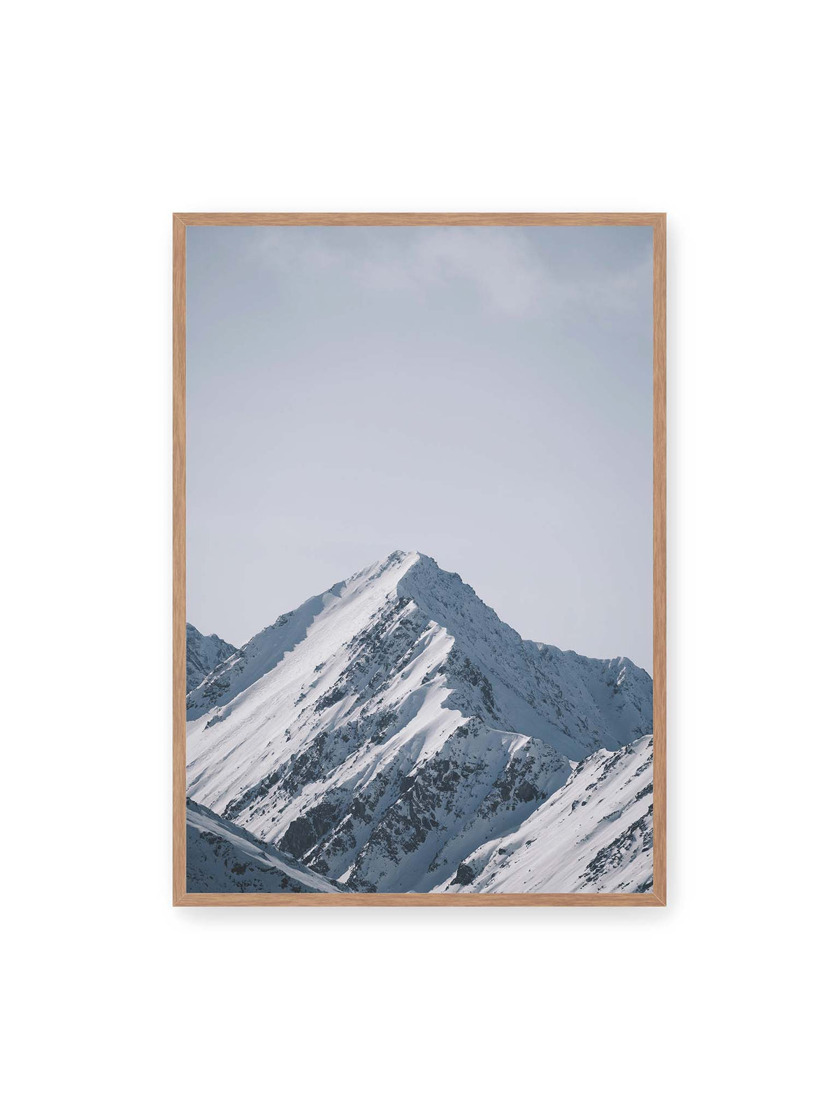 70x100 cm, Eichenrahmen – Schneebedeckter Berggipfel mit steilen Graten vor einem weiten blassblauen Himmel.